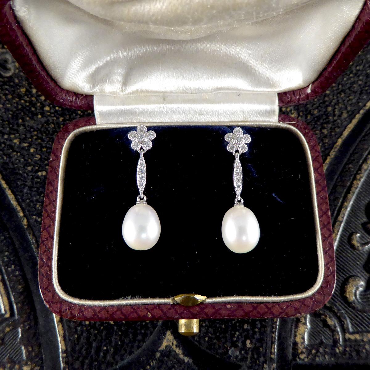 This beautiful pair of earrings have been delicately hand crafted to resemble an Art Deco period piece. Set with Diamonds is a dainty and sweet Daisy cluster millegrian set giving it the most authentic period aesthetic in 18ct White Gold. Swinging