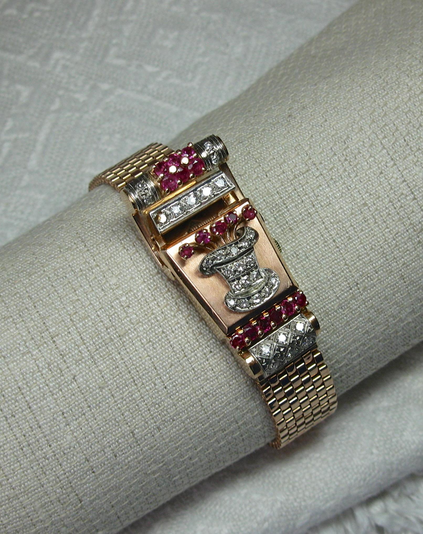 A MUSEUM QUALITY ART DECO RETRO WRISTWATCH BRACELET BY WITTNAUER - IN WORKING ORDER - IN SOLID 14 KARAT ROSE AND WHITE GOLD WITH 31 DIAMONDS AND 17 RUBIES ADORNING THE WATCH CREATING A FLOWER FILLED TOP HAT DESIGN OF EXTRAORDINARY BEAUTY!  THE WATCH