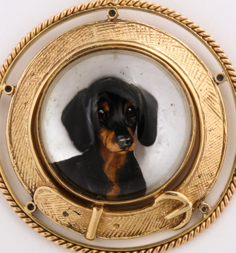 On a background of mother of pearl, popping forward as if ready to jump on your lap, a black and tan dachshund looks at you with soft eyes that seem to implore you to remain at home. Note, the slight off round of the outer frame has been made