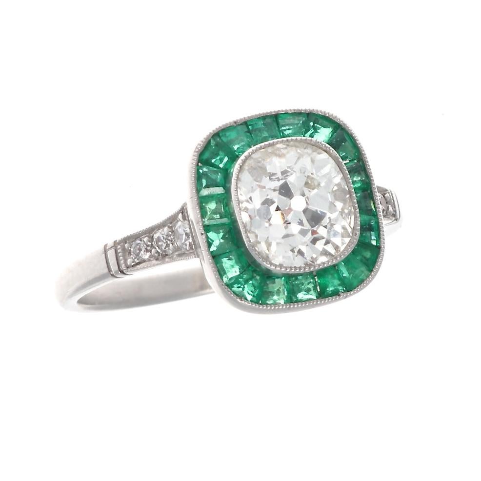 A creative and singular way of saying I love you. Featuring a 1.22 carat old mine cut diamond brilliantly surrounded by a vibrant green halo of calibrated emeralds, specially cut to mirror each facet of the diamond. Hand crafted in platinum. Ring