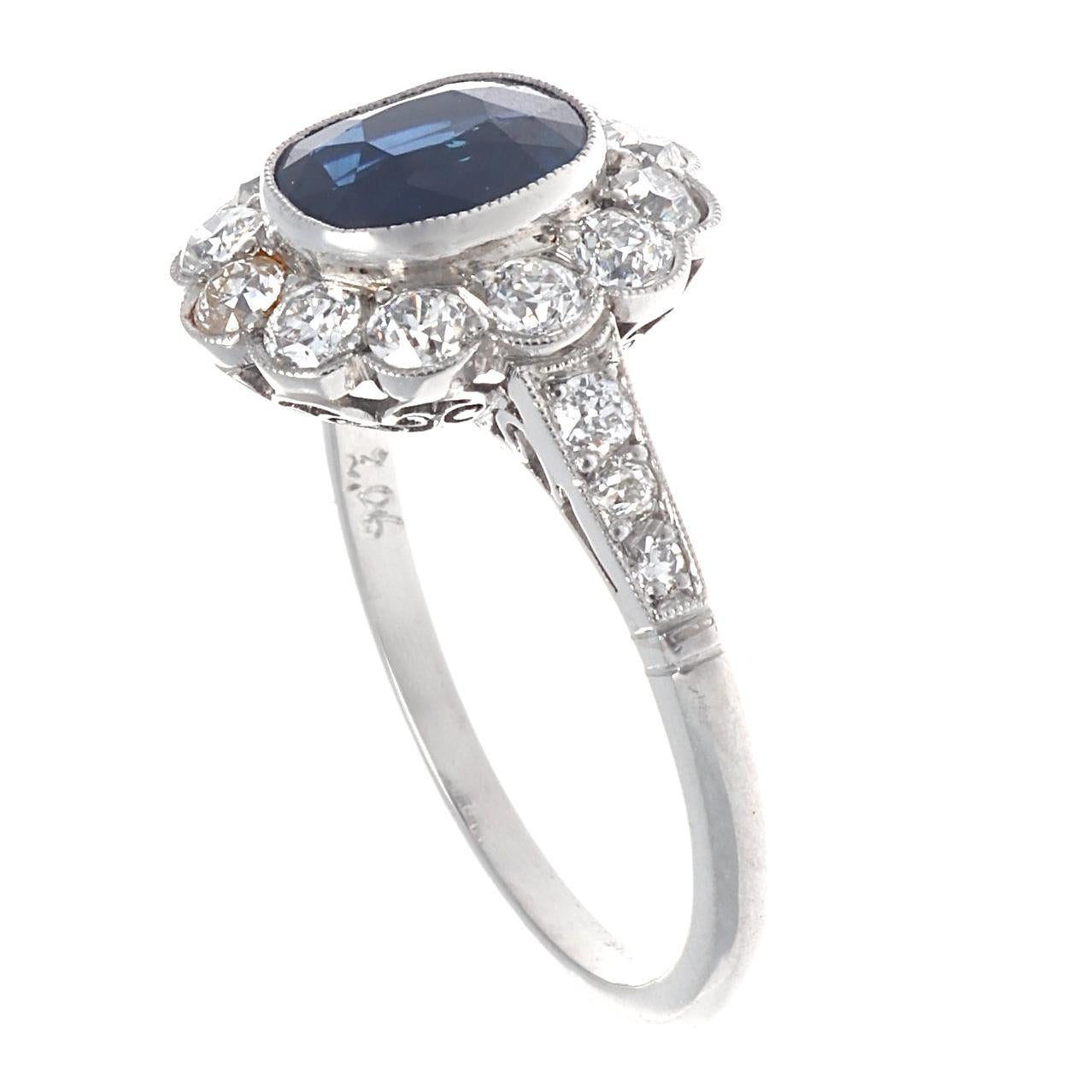 Art Deco inspired 2.06 carat sapphire diamond platinum cluster ring. Featuring 18 old European cut diamonds that weigh approximately 1 carat, graded G-H color, VS clarity. Size 7 1/2 and comes with complimentary sizing if needed. Our Guarantees: 
7