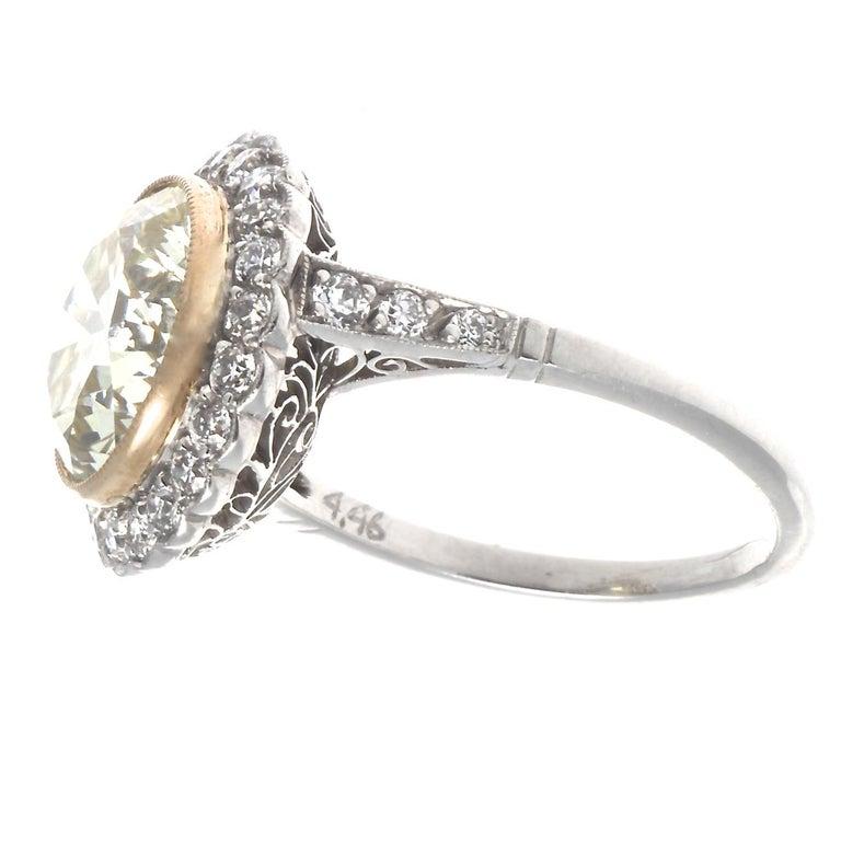 When bigger is better, this Art Deco revival diamond platinum ring delivers. Featuring a 4.46 carat old European cut diamond, graded S-T color, VVS clarity. Surrounded by 28 old European cut diamonds graded G-H color, VS clarity. Circa 2000s. Size 6