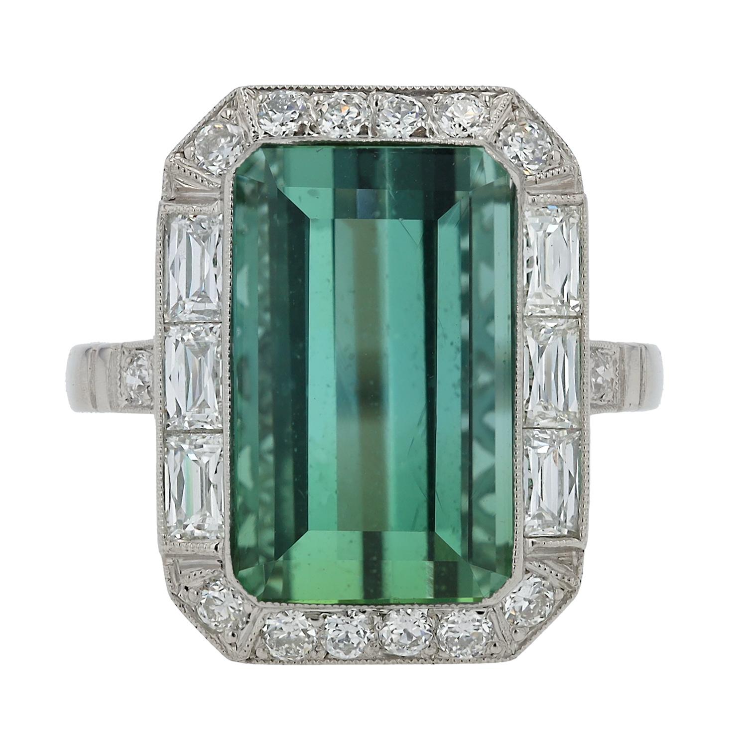 Un anello con tormalina e diamanti da 8 carati in stile Art Déco, elegante e sorprendente. La vivace tormalina verde taglio smeraldo è affiancata da diamanti taglio baguette e old mine che abbracciano l'elegante castone. Il taglio sublime presenta