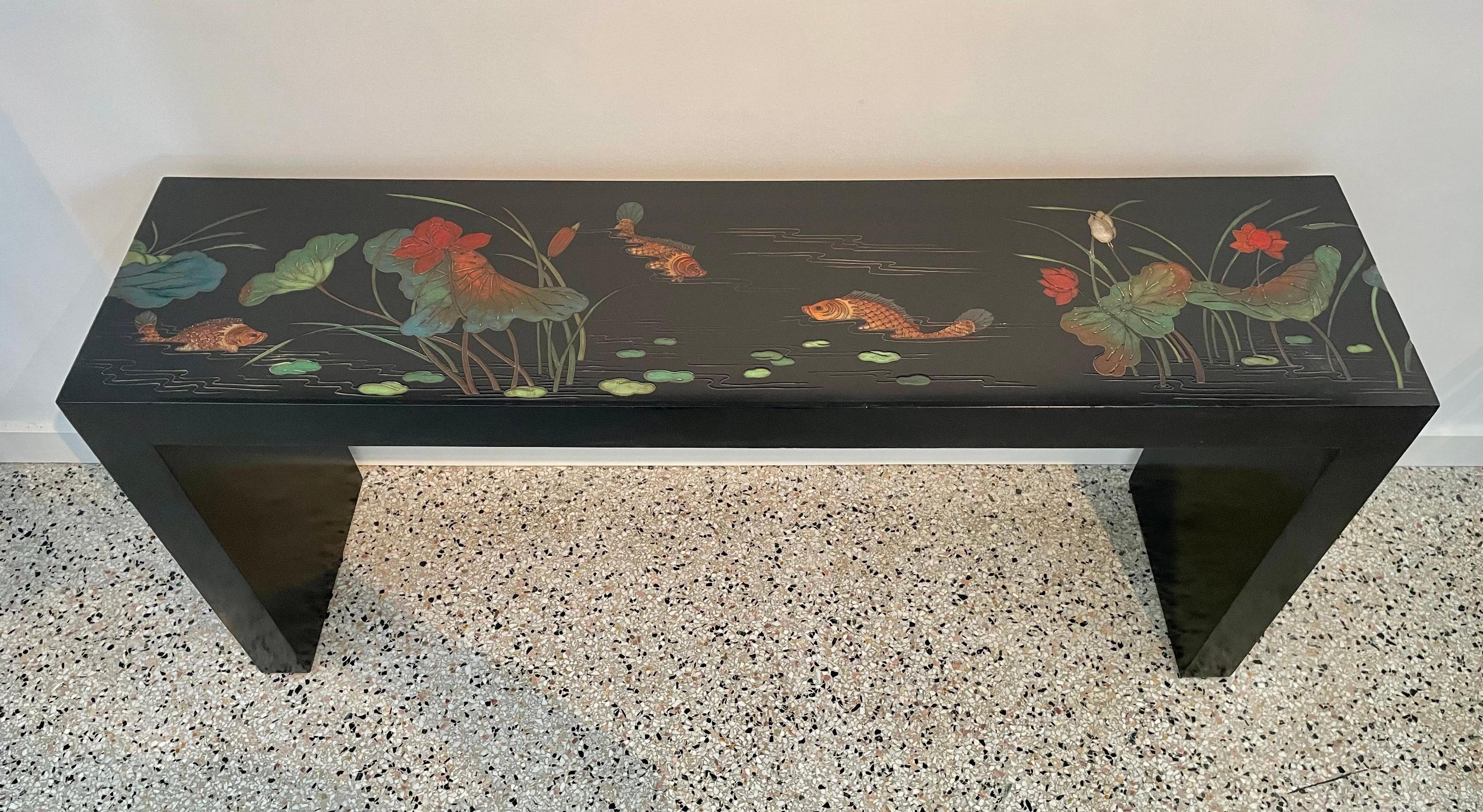 This stylish and chic console table takes its form and details from the Art Deco period in Hong Kong. The piece is detailed in a coromandel panel style with a black lacquered frame with stylized florals, and koi fish. 

