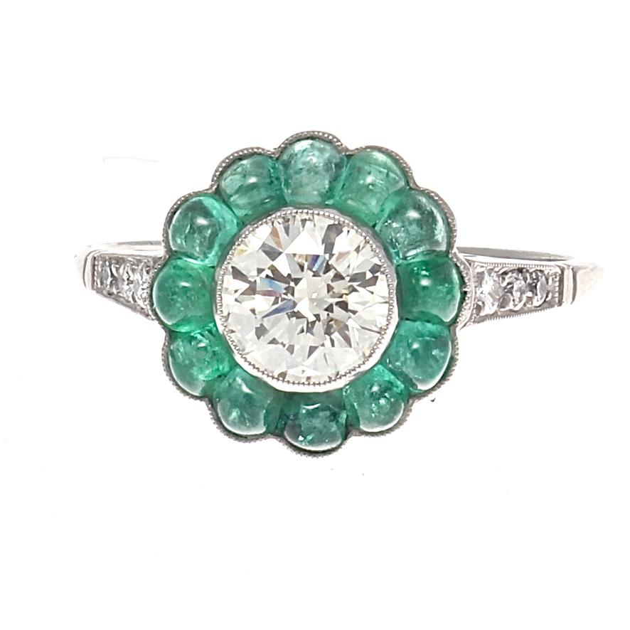 Everlasting beauty symbolizing eternal love through a forever blossoming flower. Featuring a 0.75 carat transitional cut diamond that is approximately L color, VS clarity. Surrounded by a halo of invigorating green calibrated cabochon cut emeralds.