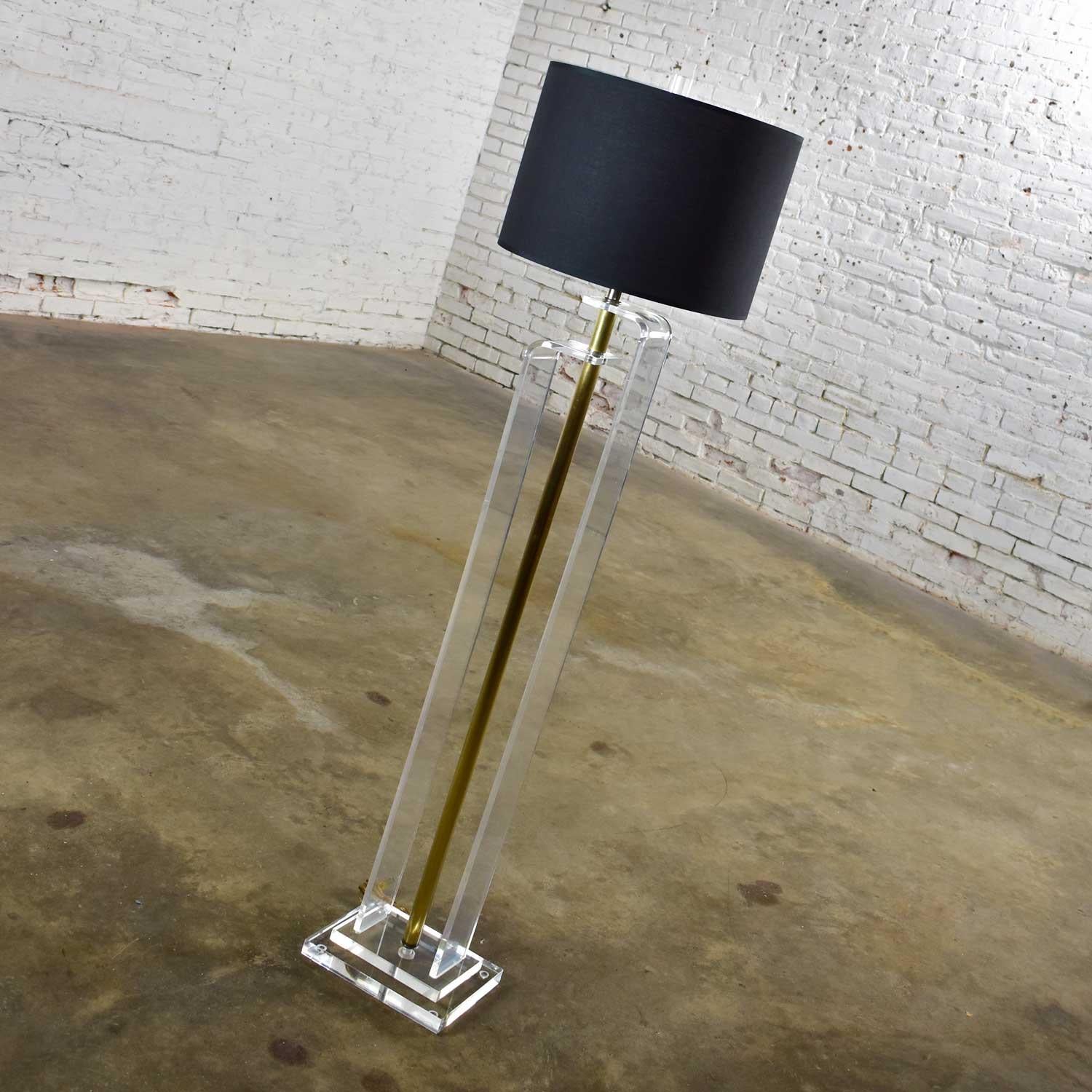 Handsome Art Deco Revival or Hollywood Regency floor lamp comprised of solid Lucite, brass plated shaft, a new black linen-like drum shade, Lucite cylinder shaped finial, and single switch socket. Gorgeous vintage condition. All parts were cleaned,