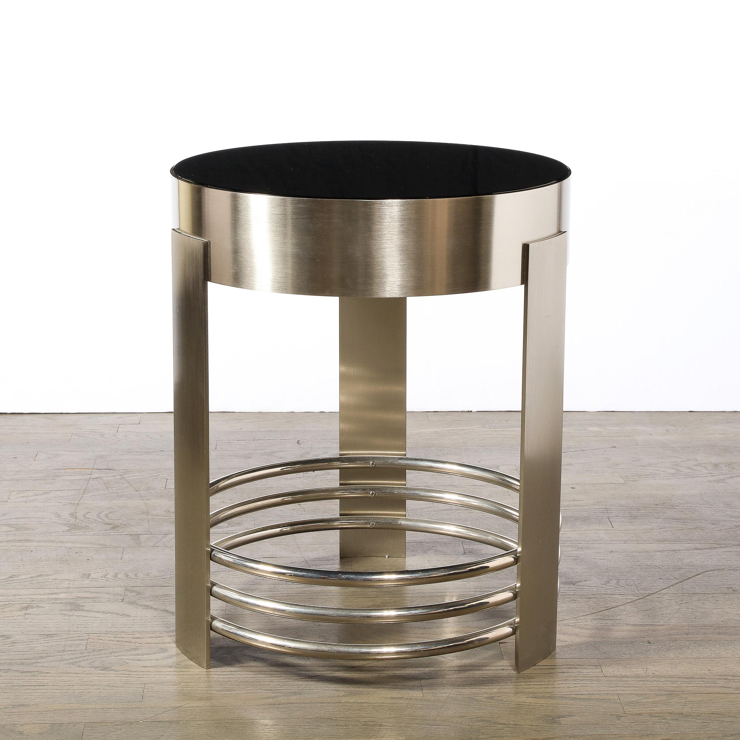 This stunning and impactful Art Deco revival occasional table was realized in the United States during the latter half of the 20th century. It features three rectangular supports in brushed nickel connected on the interior by three stacked