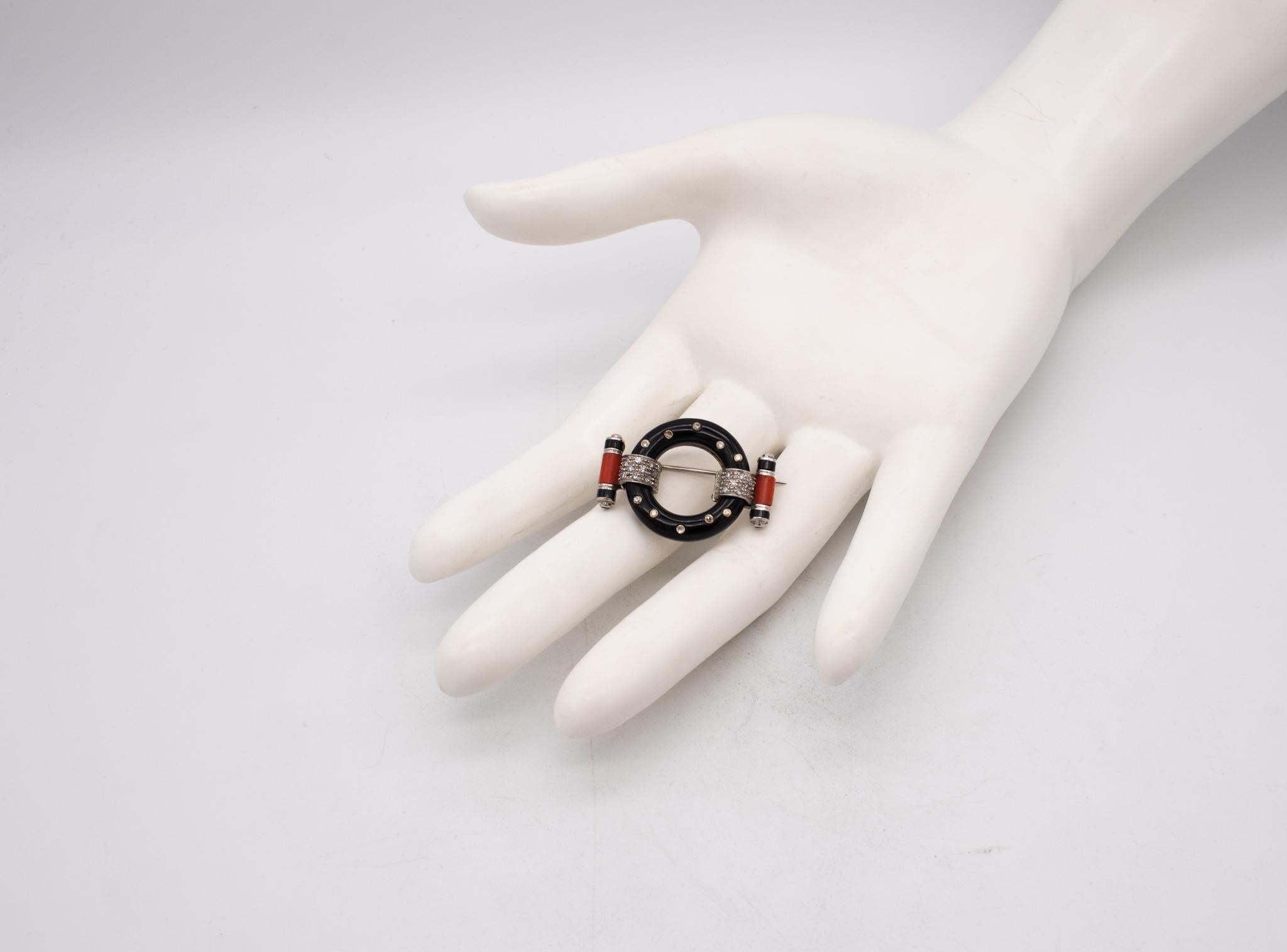 Very handsome Art-Deco pin brooch.

An art deco revival piece, crafted in 18 karats white gold and suited with a hinged horizontal pin with a lock. They are embellished with carvings of natural black onyx and vivid red coral.

Set with 28 round