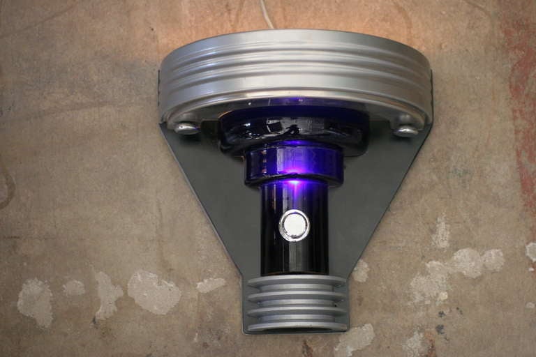 In what can only be described as futurism, this stunning pair of Art Deco Revival Machine Age styled wall Sconce features a light up cobalt glass center column and hand-machined steel fittings.

It is an Art Deco Revival masterpiece produced and