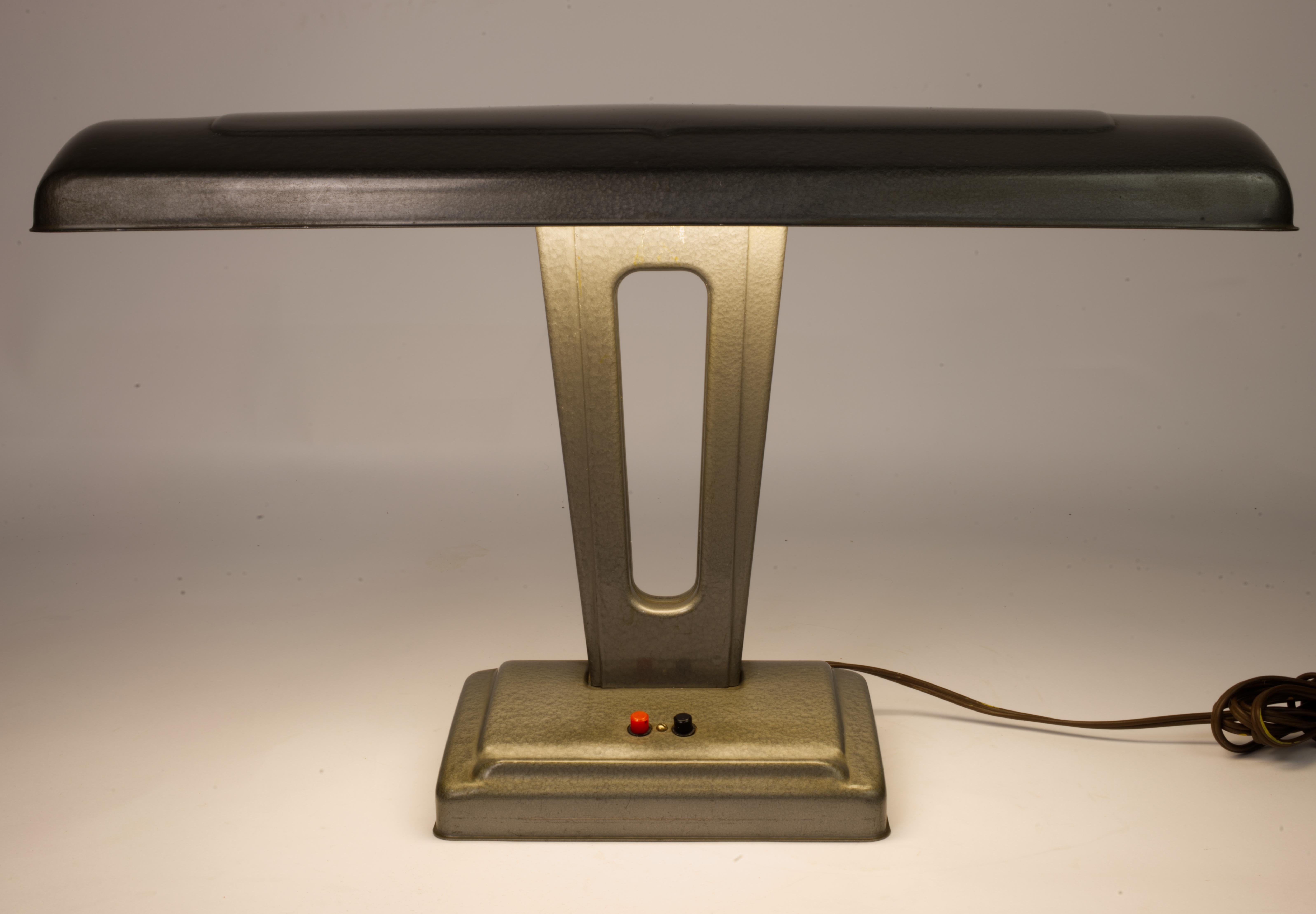 Art Deco revival desk lamp produced around 1950s. 
Lovely design. Lamp housing shape is reminiscent of Glenn H Curtiss early planes. Whoever designed it must have been a fan. 
Both lights work. As with majority of florescent lights, it emits a very