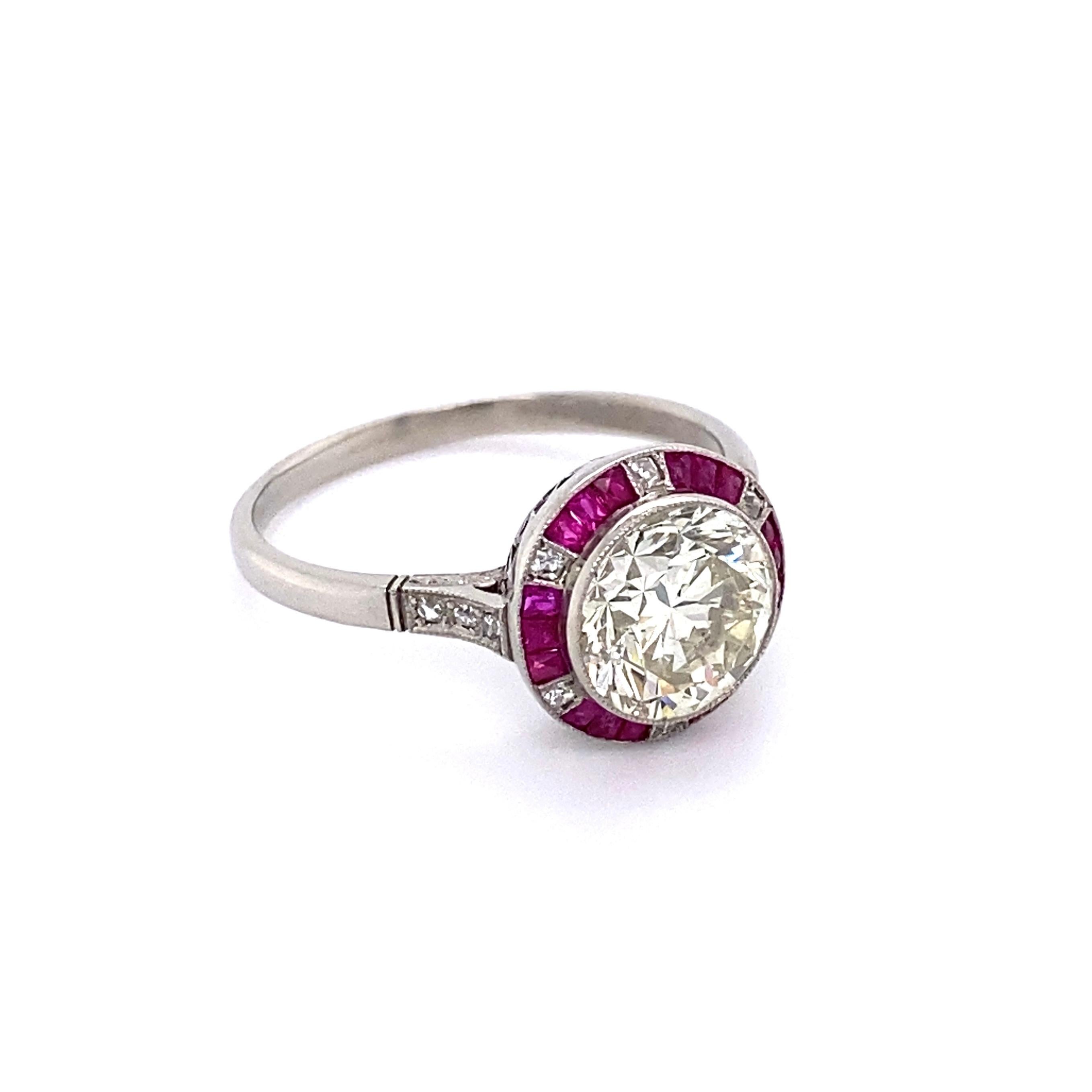 Simply Beautiful! Finely detailed Art Deco Style Platinum Cocktail Halo Ring, center securely nestled with a Transitional Round Diamond, approx. 2.81 Carat. Color brown tint M and clarity is SI2/I1. Surrounded by calibrated Rubies, approx. 0.78tcw