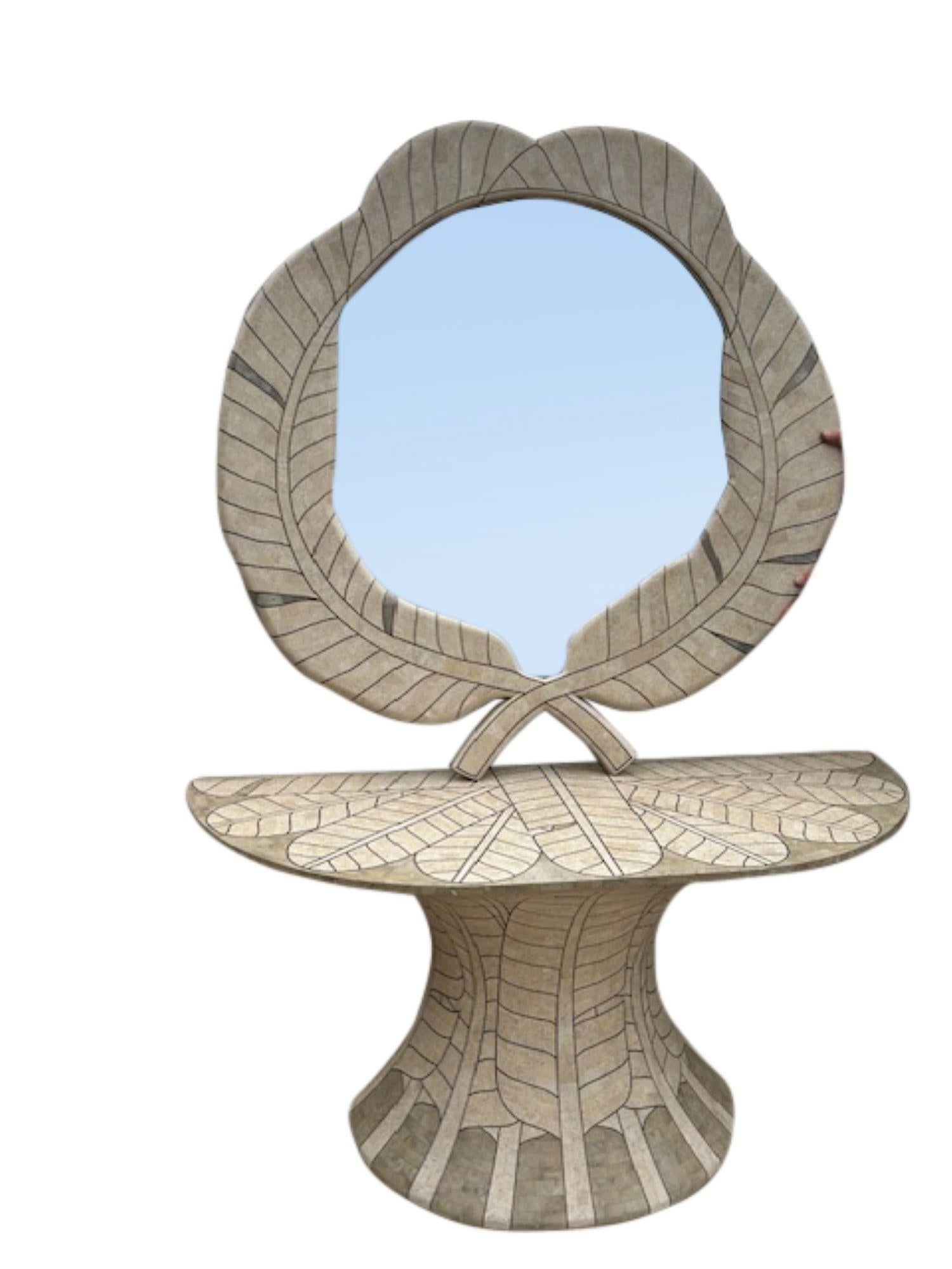 A striking postmodern mirror and console table set attributed to Maitland-Smith, crafted in the 1980s. The Art Deco revival ensemble features tessellated travertine stone inlaid with brass detailing, forming a sophisticated leaf-like pattern that