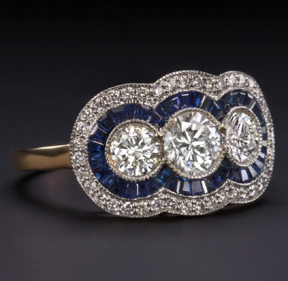  Bright white and exceptionally clean, the three round brilliant cut center diamonds offer phenomenal sparkle! These high quality diamonds are accented by a double halo of calibre cut sapphires and diamonds. The effect is truly eye catching and
