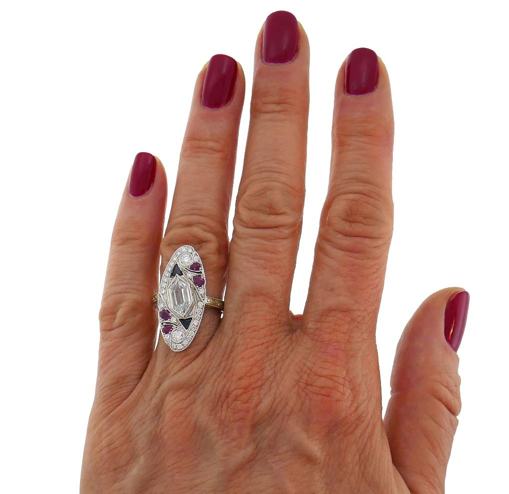 Classic Art Deco style ring. 
Made of 18 karat white gold, the ring features rose cut diamond accented with round brilliant cut diamonds, ruby and sapphire. The rose cut diamond measures 10.13 x 5.14 x 2.43 mm and is I color, SI2 clarity. The