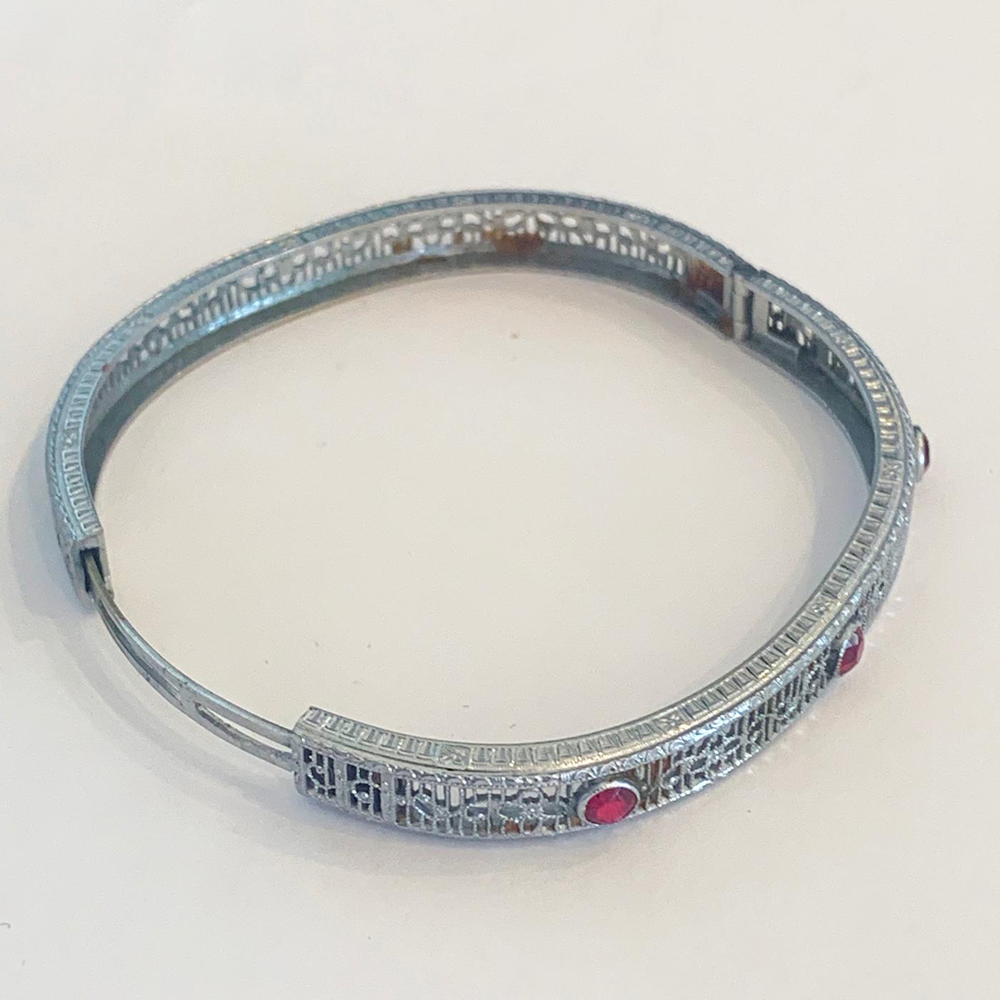 Art Deco Rhodium Elliptical shaped, delicate design Bangle, set with 3 Red Paste Stones, with Slide Opening Clasp. All in very fine filigree with an etched design to the perimeter on both sides. All in absolute perfect condition, with no damage or
