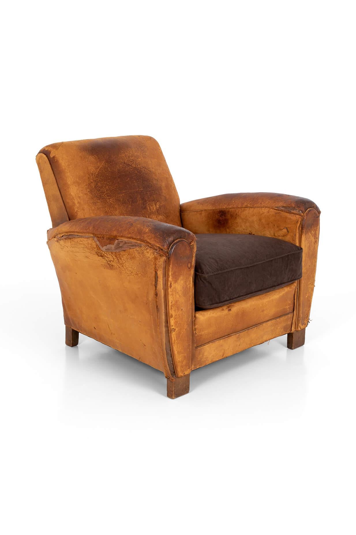 A superb distressed Art Deco club chair in a rich tan leather. Square back on oak frame with scrolling arms. Fully reconditioned coil sprung seat with a new dark brown suede feature cushion. 

French, circa 1930.

Additional