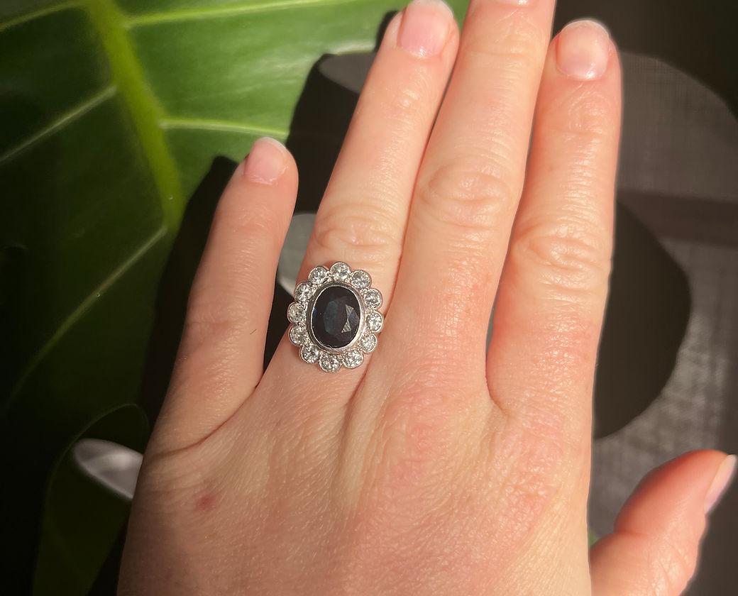 Art Deco Pompadour Ring (1930-1935) in 18 Carat White Gold (750/1000) and Platinum.
It is centered with a natural oval sapphire of approximately 2.40 carats, surrounded by 12 old-cut diamonds totaling approximately 1.10 carats.

Detailed