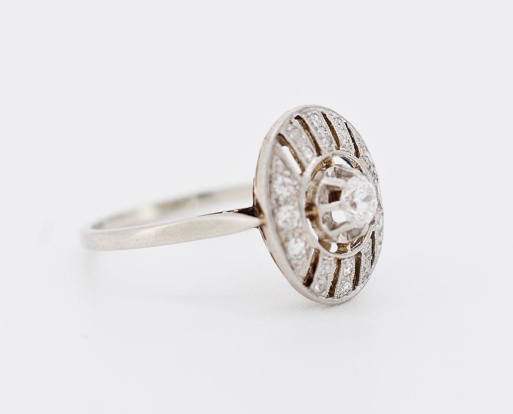 Questo anello Art of Vintage (circa 1920) è realizzato in oro 18 carati (750 millesimi) e platino. L'anello ha un design ovale e geometrico, con diamanti taglio rosa incastonati, di cui quello centrale pesa circa 0,15 carati, per un peso totale di