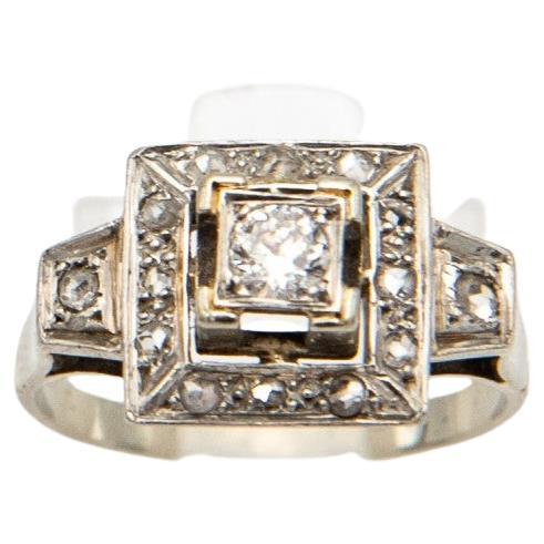 An old Art Deco ring made of platinum and 0.750 white gold and diamonds

A geometric composition typical of the Art Deco style.

The central diamond weighing approx. 0.15ct (color/purity - F/VS) surrounded by 14 smaller diamonds with a total weight