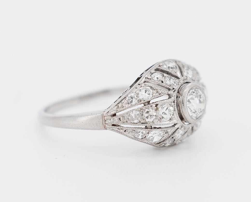 Antique Art Deco ring (1920s) in platinum. It is set with an old-cut diamond of approximately 0.30 carats in the center, surrounded by rose-cut diamonds for a total of approximately 0.60 carats.

Detailed Characteristics
Weight: 4.4g
Size: 55 FR