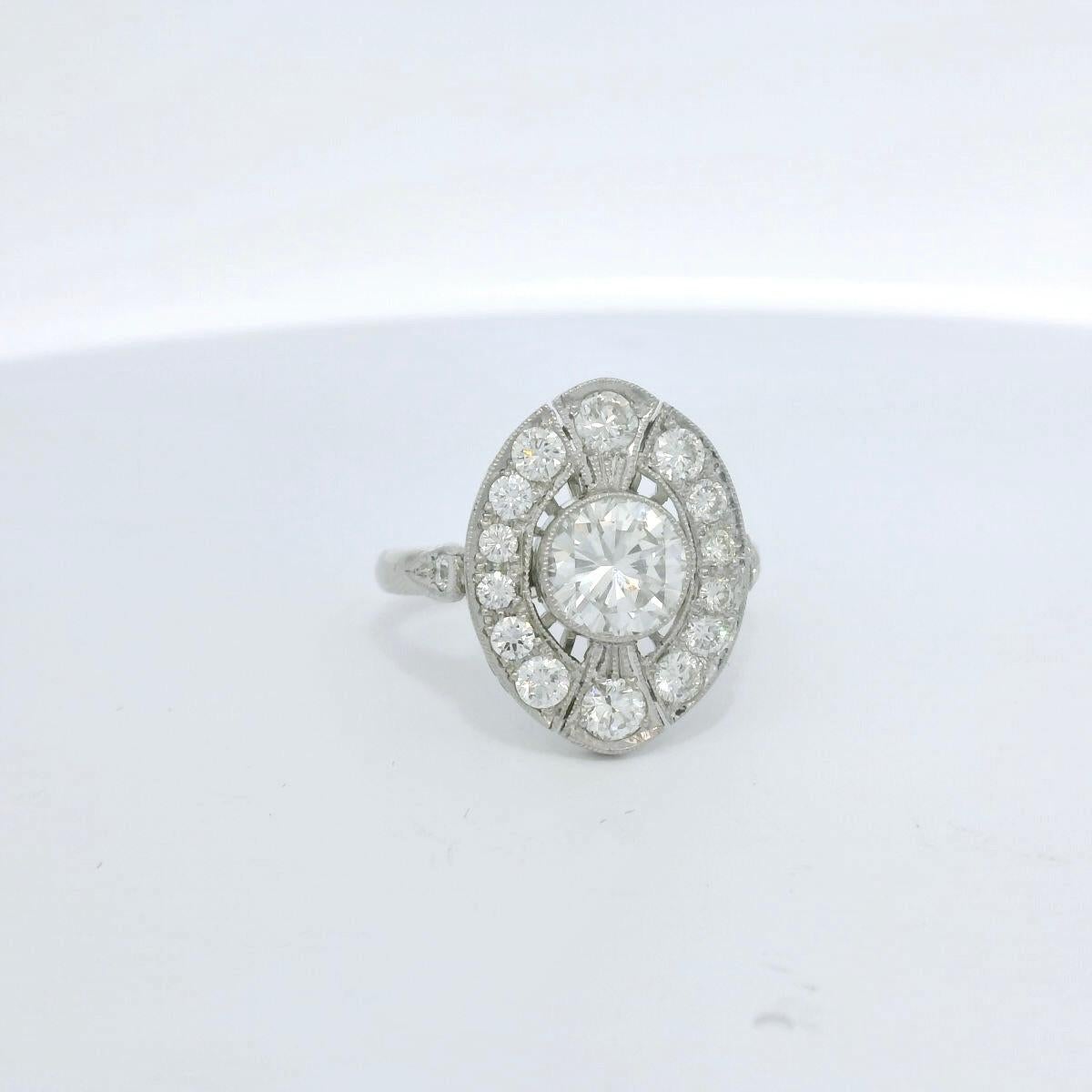 Very delicate diamond ring set with a center brilliant cut diamond of 1.01 Carats ( estimated J color - Si clarity ; very pleasant Si on the lower side of the diamond) and 16 brilliant cut diamonds for a total of approximately 0.75 Carats (