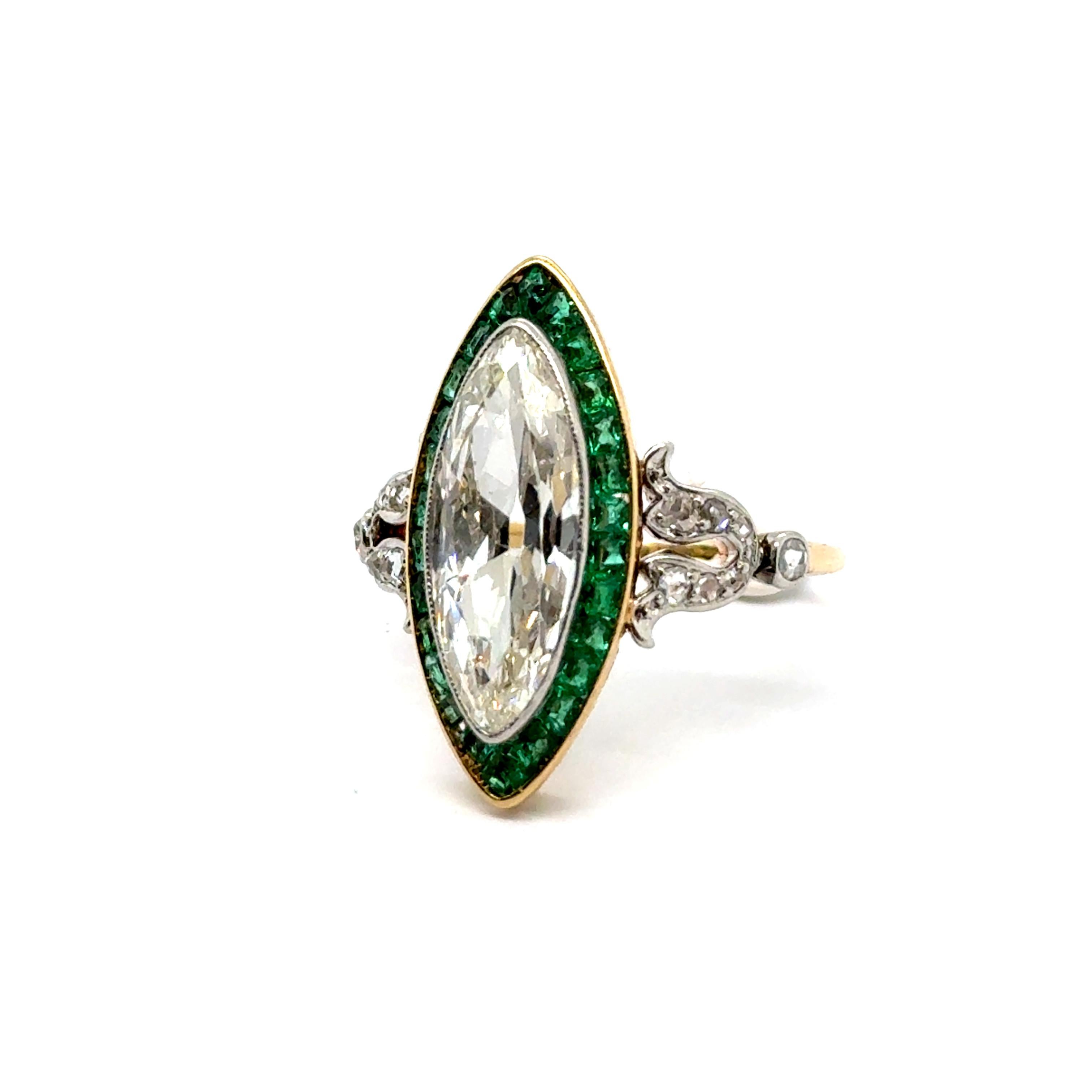 Discover this exquisite Art Deco ring, crafted in 18 karat yellow gold and platinum, adorned with Diamonds & Emeralds. 

At its heart shines a dazzling 2.20-carat marquise-cut diamond, complemented by 14 delicate rose-cut diamonds and 26 vibrant
