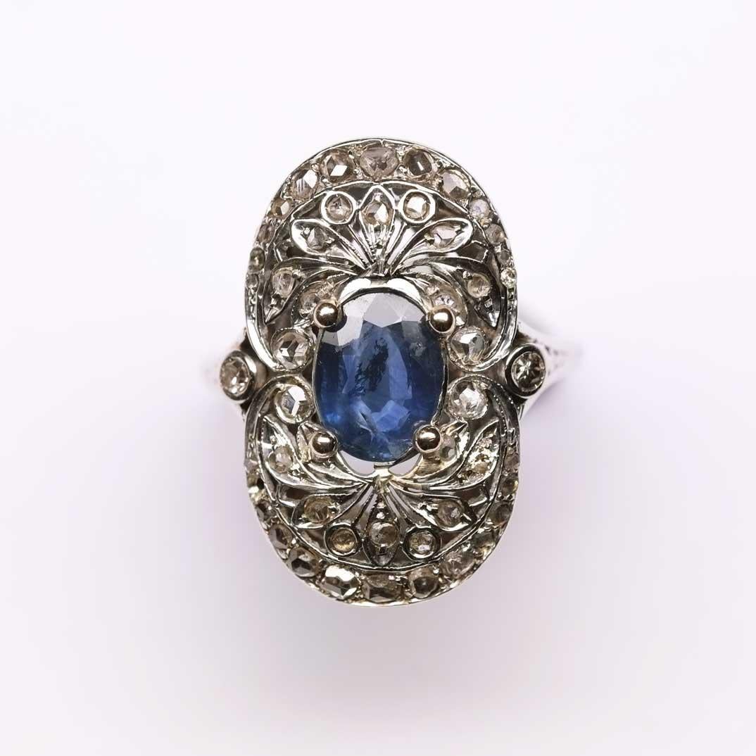 Beautiful oval shaped Art Deco ring set in white gold with sapphire in centre surrounded by rose cut diamonds.