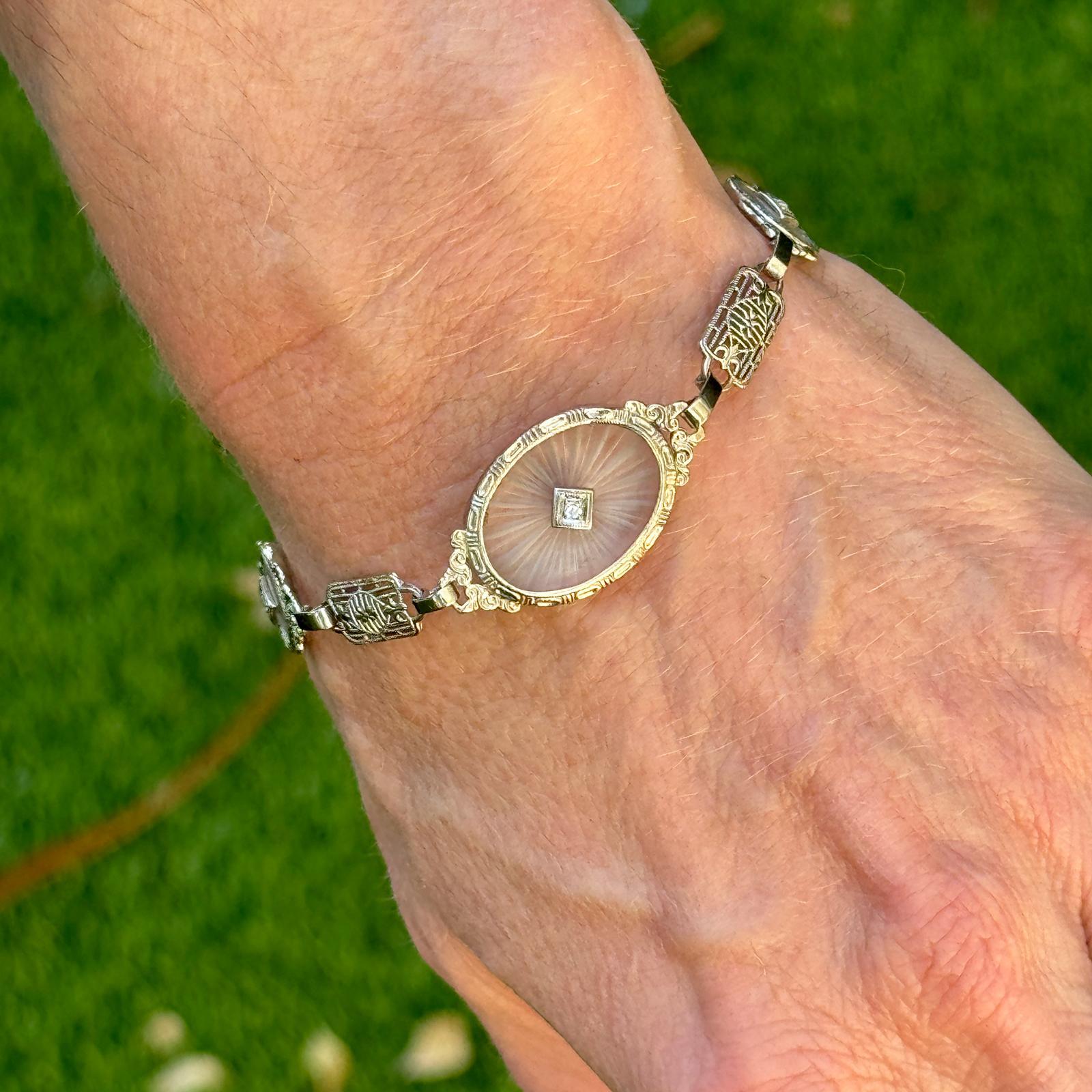Bracelet Art déco filigrane en cristal de roche et diamants datant de l'époque Art déco des années 1930. Réalisé en filigrane d'or blanc 14k, le cristal de roche sculpté est surmonté de 3 diamants ronds à facettes d'un poids approximatif de 0,05