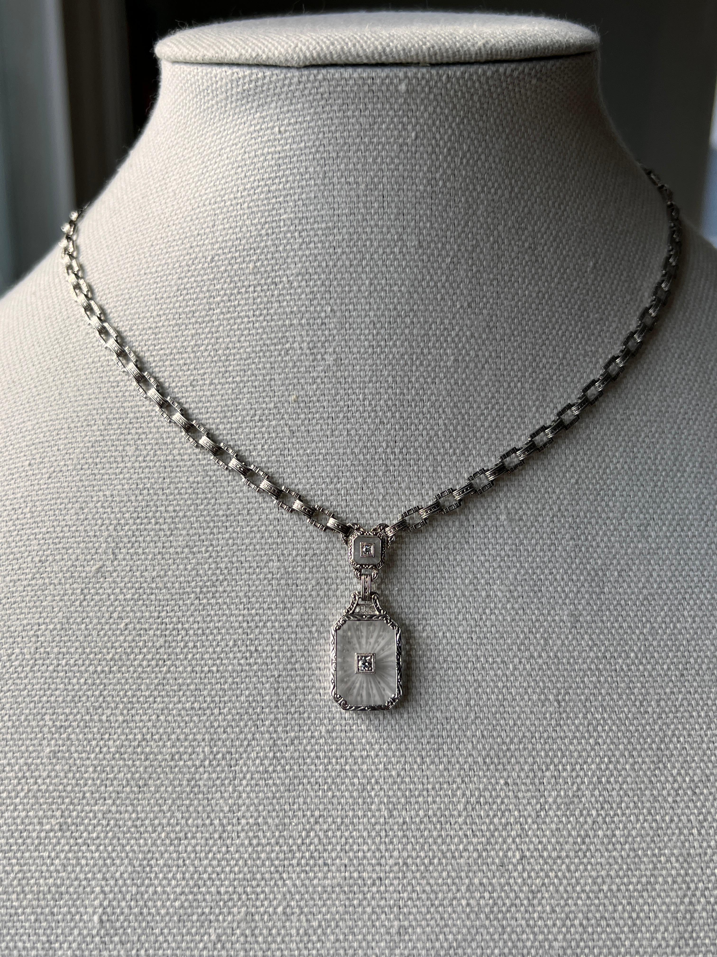 Questa collana Art Deco in cristallo di rocca in oro bianco 14 carati è un esempio di design anni '20. Con una lunghezza di 16 pollici, la sostanziosa catena a maglie fantasia mostra il classico stile geometrico Art Deco con maglie rettangolari