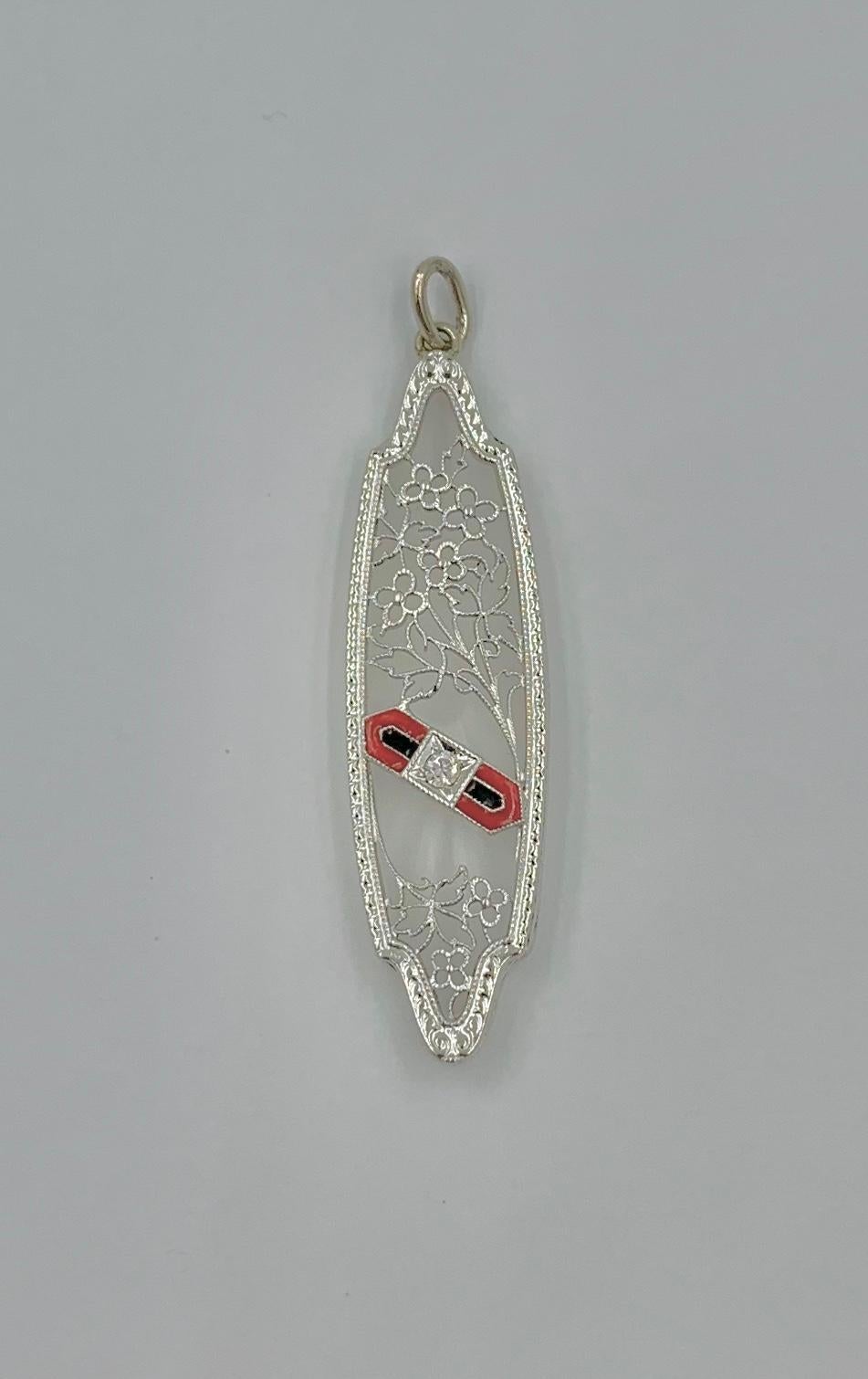 A very special antique Edwardian, Art Deco pendant with a central panel of Rock Crystal with a Diamond and Enamel center and flower and leaf filigree design in 14 Karat White Gold.  This is one of the most beautiful Art Deco Rock Crystal pendants we
