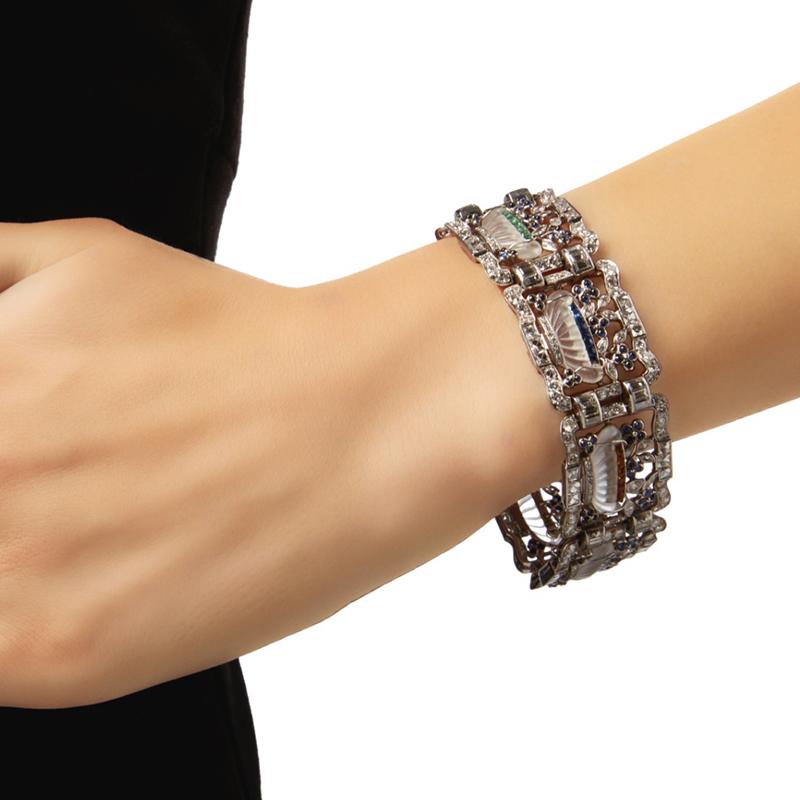 An Art Deco Rock Crystal, Gem-Set and Diamond Bracelet. The acrostic bracelet composed of seven links set with carved rock crystal vessels, trimmed with French-cut diamonds and calibré-cut colored stones spelling out the word 'dearest', containing
