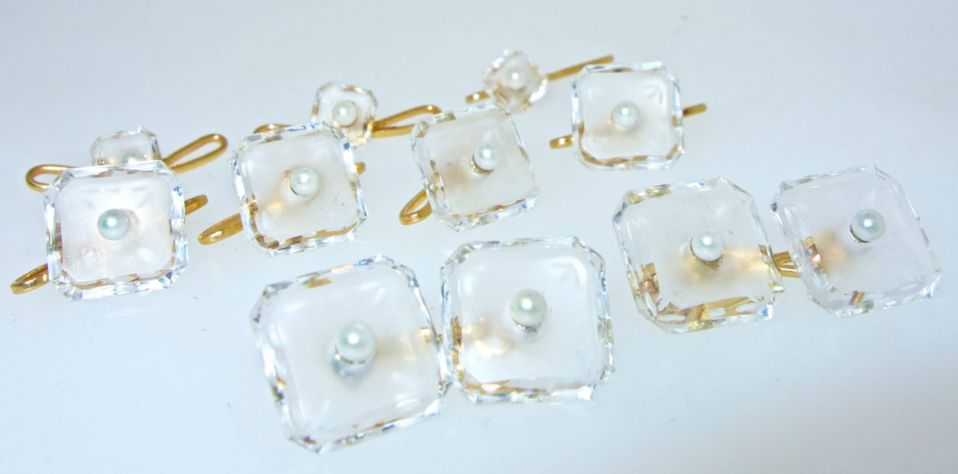 Faceted, frosted and etched rock crystal centering a natural pearl, this set made in the late 1920's, has three shirt studs, four vest buttons (which can also be worn as 4 shirt studs), and back to back cufflinks.  In fine condition this Art Deco