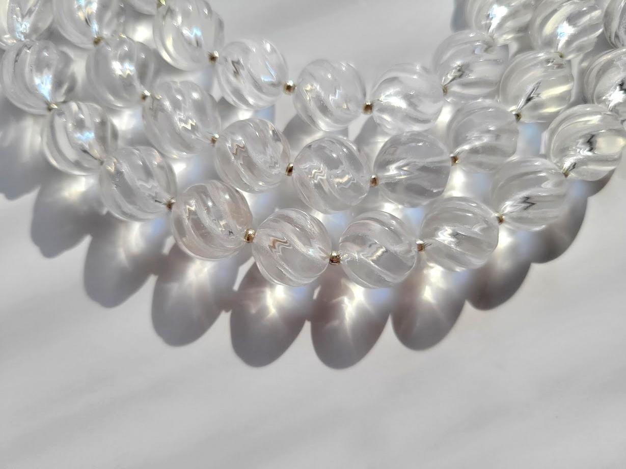 Collier de perles en cristal de roche véritable sculpté en forme de tourbillon 

La longueur du collier est de 91,5 cm. La taille des perles sculptées en tourbillon est de 12 mm.
Le CRISTAL DE ROCHE est une variété de quartz transparent et incolore,