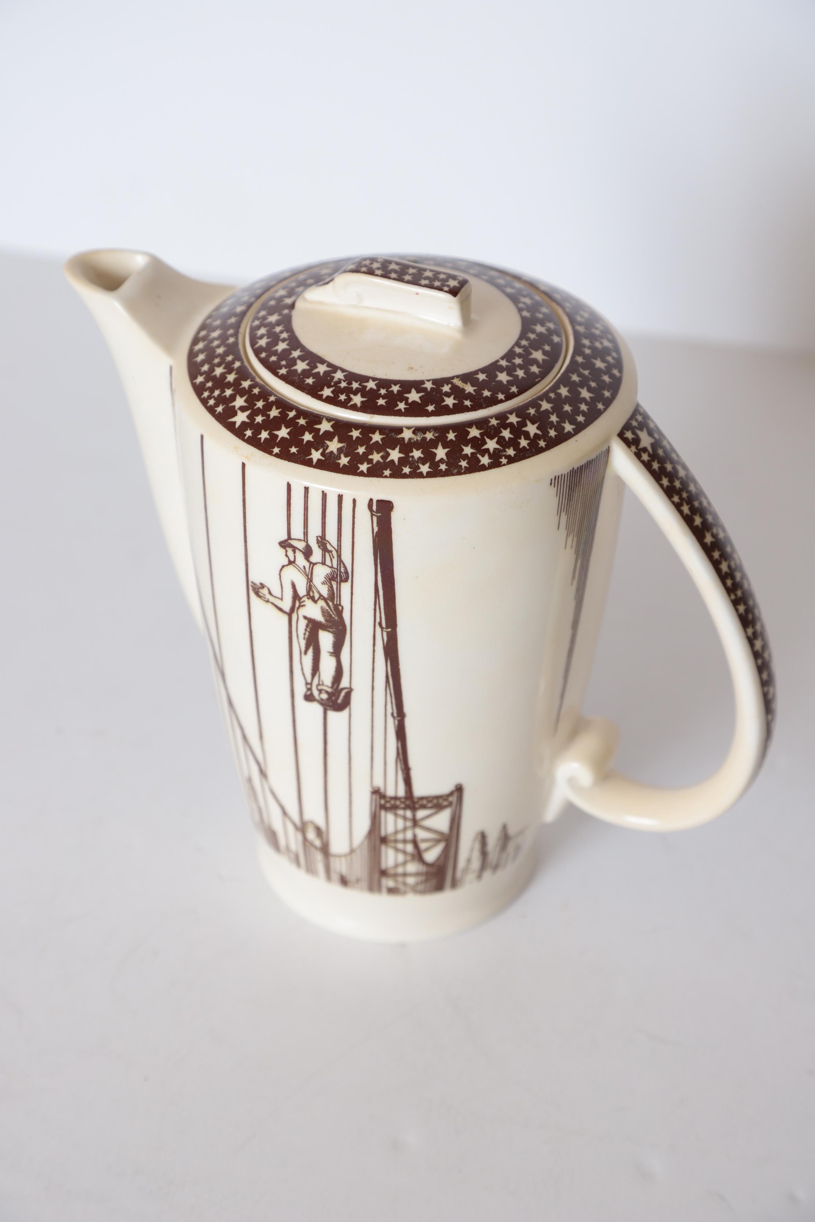 Art Deco Rockwell Kent our America coffee pot for Vernon Kilns cocktail pitcher

Classic Kent masculine machine age Industrial Design.
Worker on a suspension bridge like the Golden Gate or Brooklyn bridges with city-scape skyscraper background.