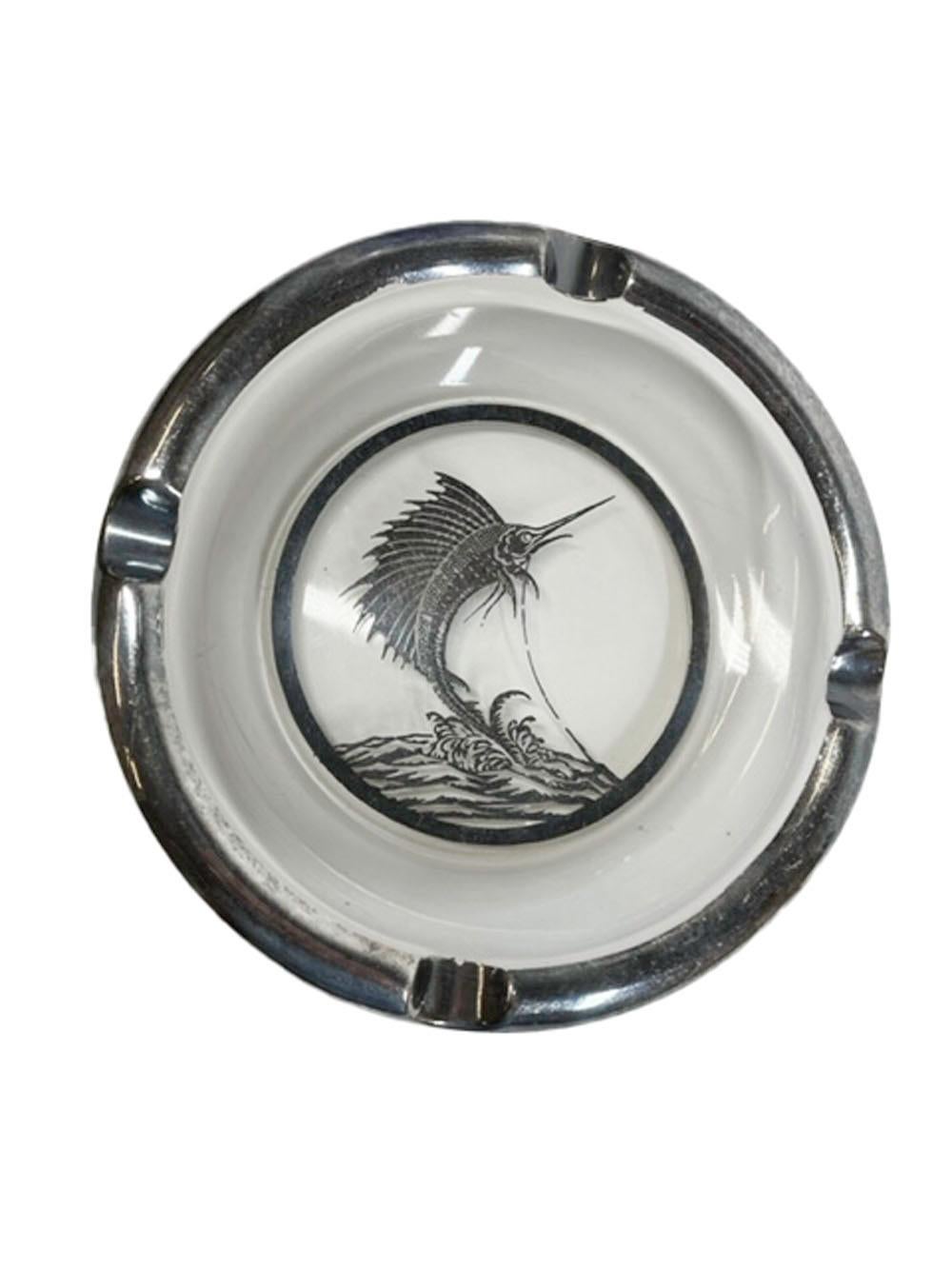 Art Deco silver overlay ashtray by Rockwell Silver Company with a silver overlay four divot rim centering a hooked leaping marlin over waves.