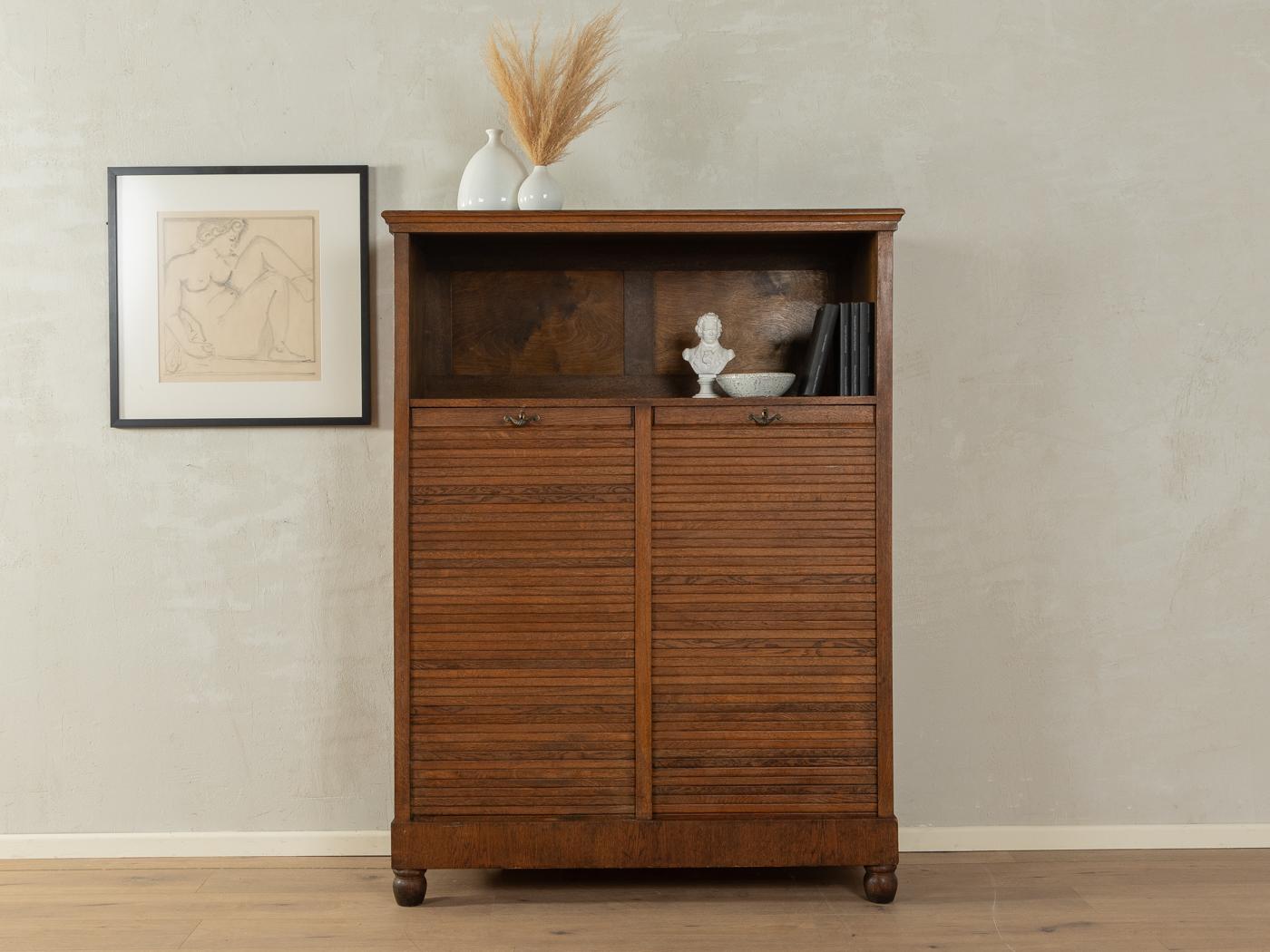 Unique Art déco roller shutter cabinet from the 1920s. Corpus in dark stained oak veneer with sixteen shelves and time-typical feet.

Quality Features:

    very good workmanship
    high quality materials
    Made in Germany

 Measurements