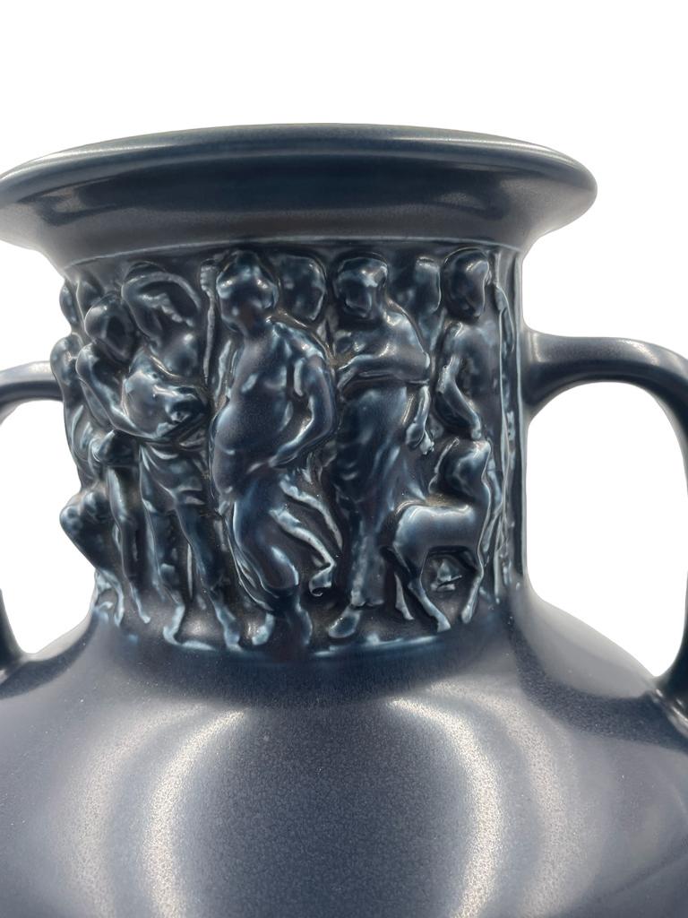 ROOKWOOD POTTERY CO. Production urn in Dark Blue Mat glaze with classical style frieze panels at neck, Cincinnati, OH, 1929; Flame mark, date and model shape  6125, dated 1929

Size: 12.5 inches x 6 inches diameter of the base
1529
Rookwood pottery