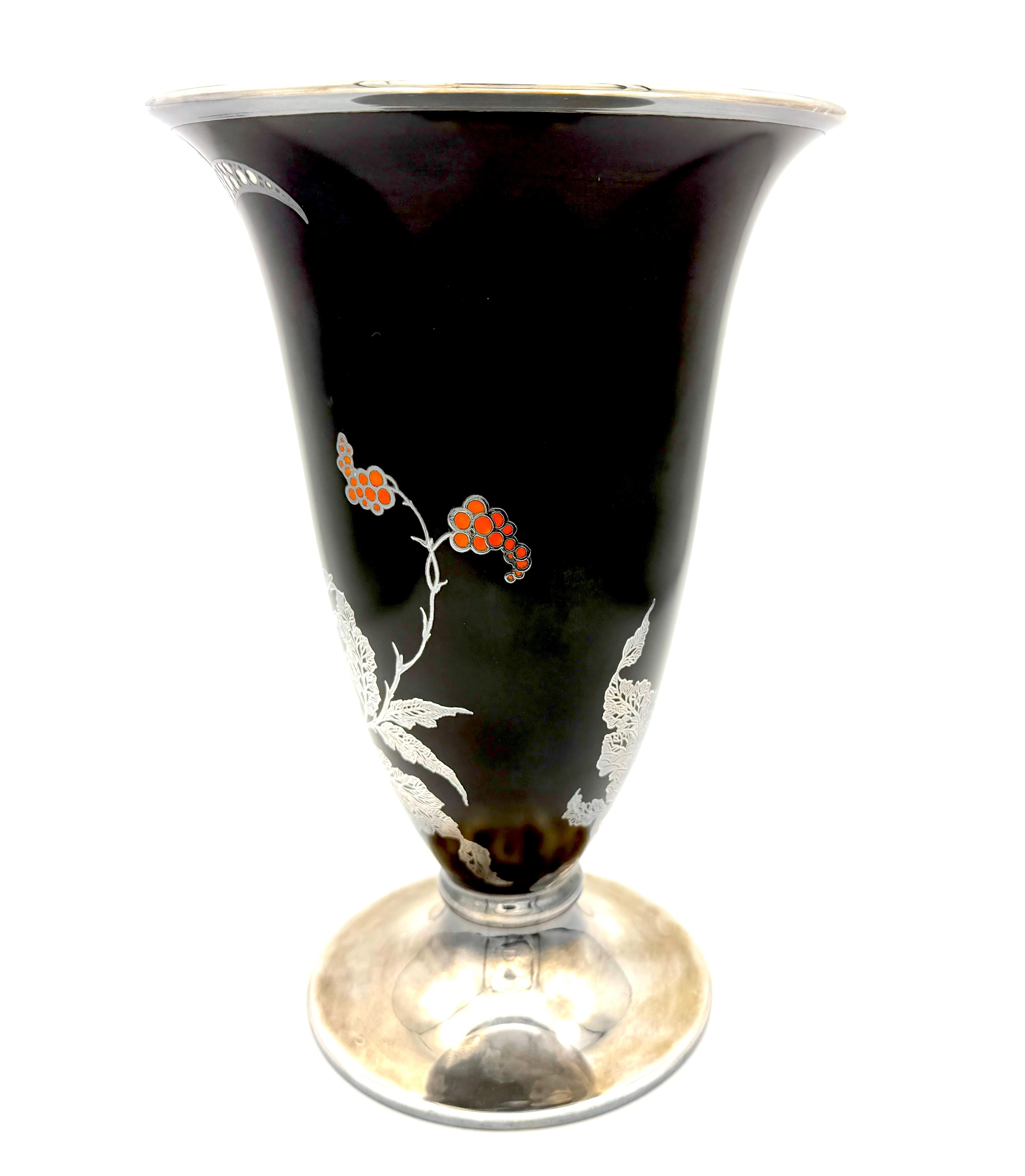 This stunning Art Deco porcelain vase was created in the 1930' by Rosenthal. The rim and the foot have been overlaid with silver. The vase is decorated with a colourful rooster inflight amidst flowers before a black backgrund.