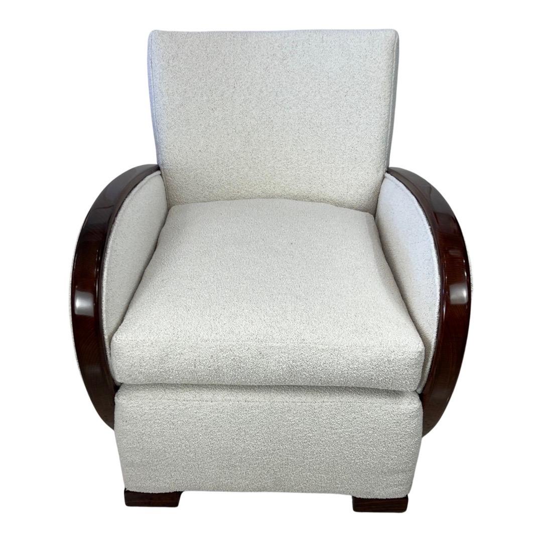 Art Deco club chair with Bouclé fabric and Rosewood arms is a stunning example of early 20th century Furniture design. The low back an deep seat make it a comfortable piece for lounging, while the sleek lines and geometric shapes are quintessential