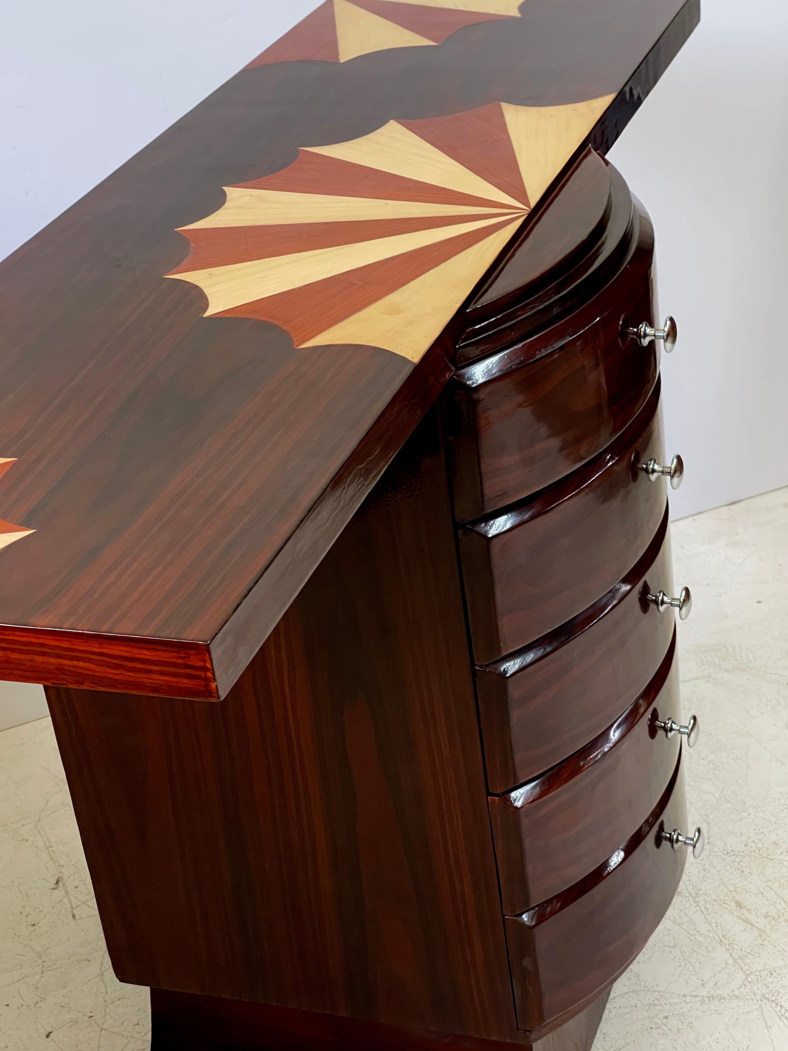 20th century Italian rosewood console or sofa table in the style of Art Deco having a fan inlaid top inset over a bowfront pedestal holding five drawers and resting on an upswept platform base.