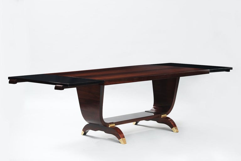 Rosewood Art Deco extendable dining table, lyre-shaped foot and brass caps on the legs.
Measures: Width: 170cm (closed), 260cm (open).

