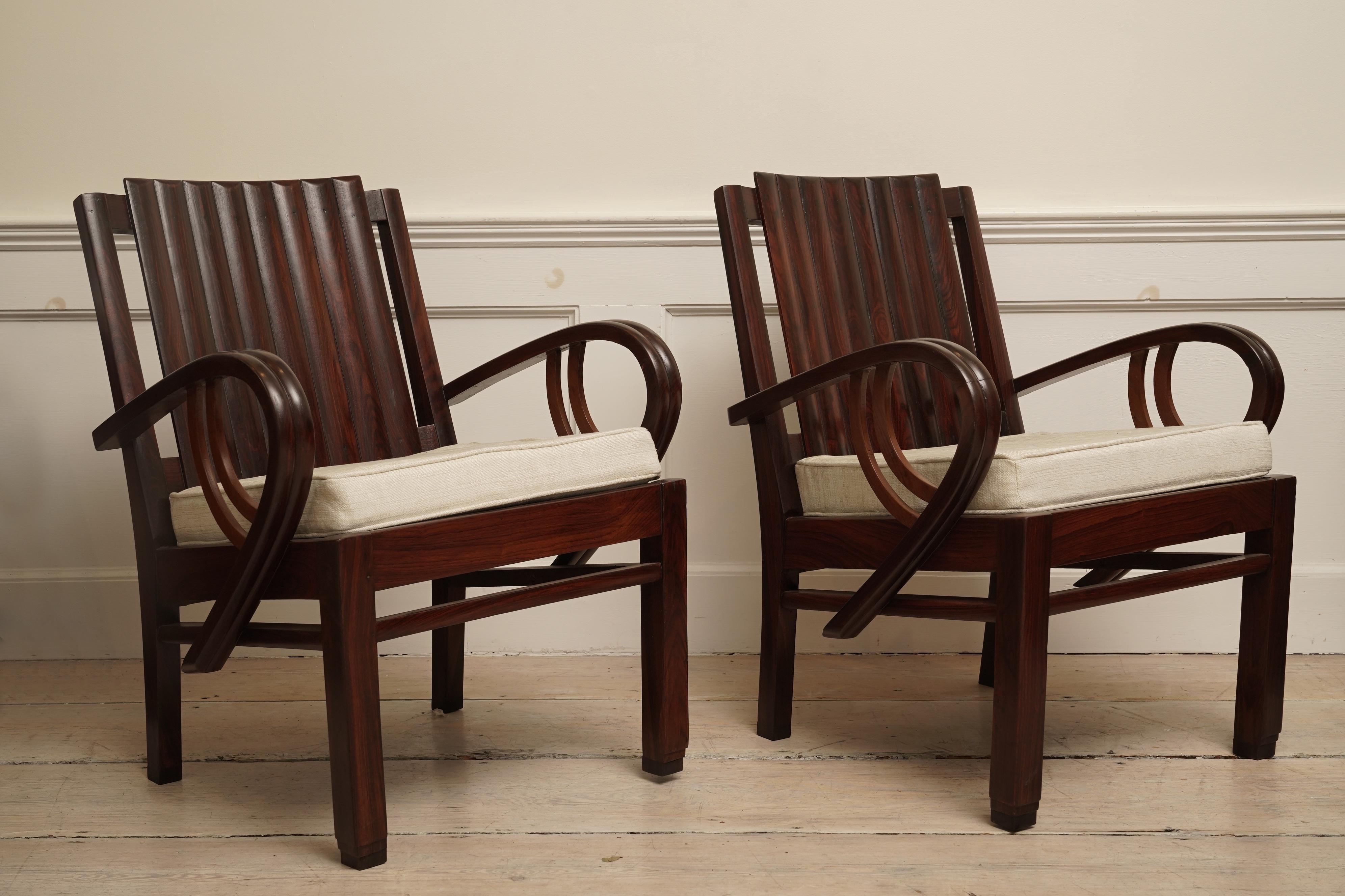 An incredible Art Deco rosewood suite of three pieces loveseat and pair of chairs. Slatted back with curled arms and stepped feet. The loveseat is 51