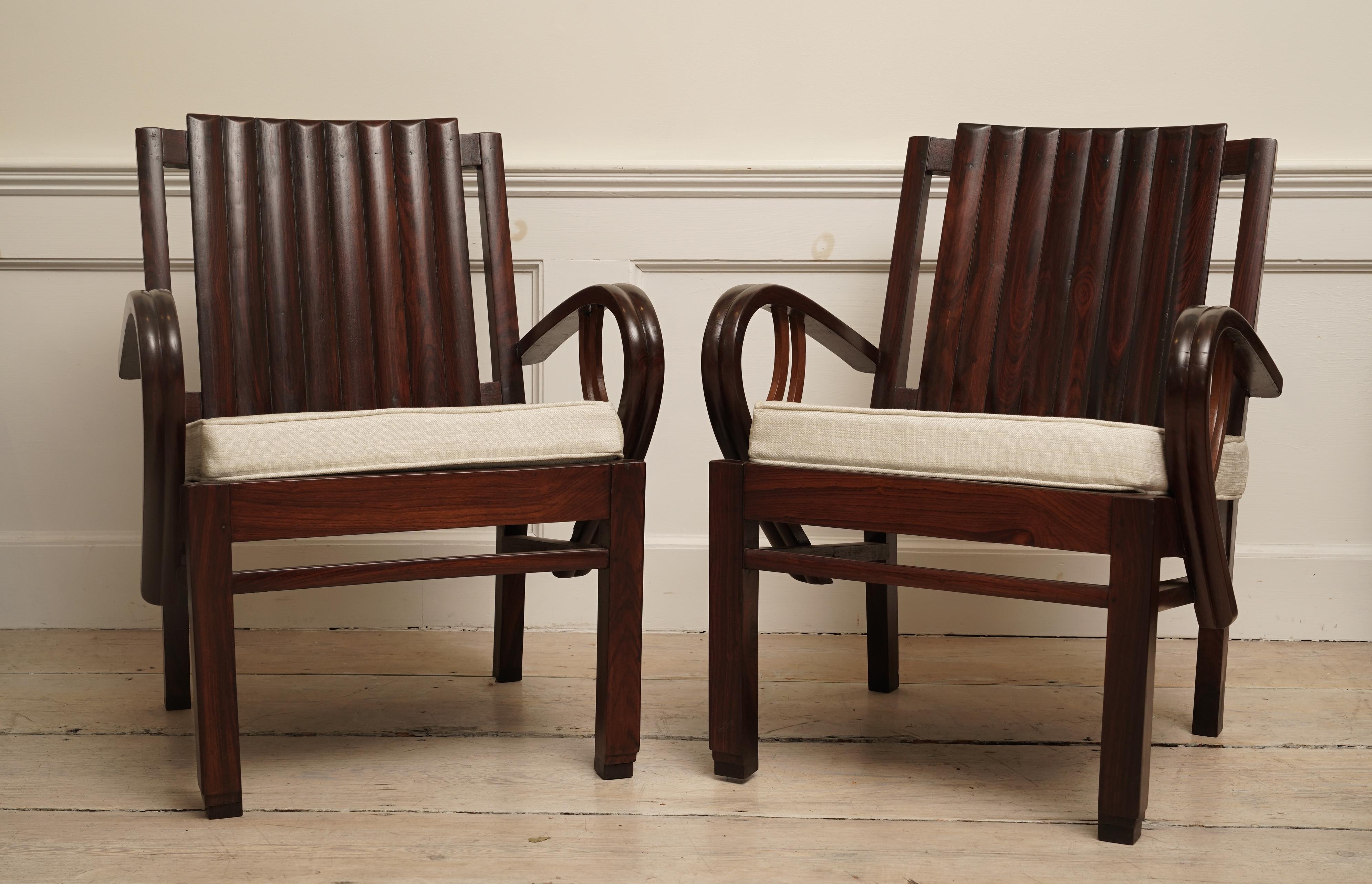 An incredible Art Deco rosewood pair of chairs with great lines. Beautiful, exotic rosewood with slatted back with curled arms and stepped feet. The love seat is 51