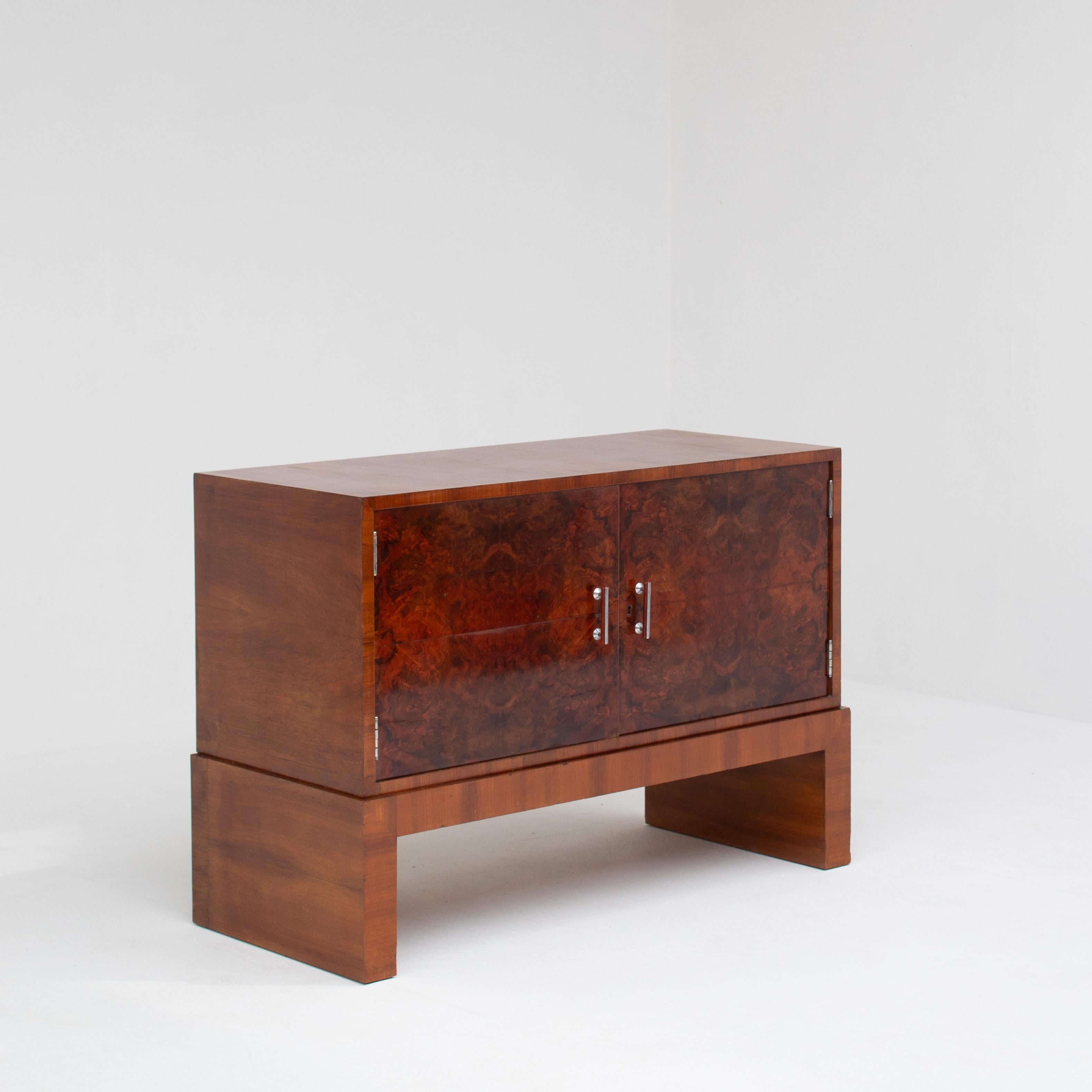 Cet exceptionnel buffet Art déco des années 1930 est un véritable chef-d'œuvre d'artisanat et de design intemporel. Fabriquée en palissandre luxueux et ornée d'un étonnant placage de ronce, cette pièce rayonne d'élégance et de sophistication. Les