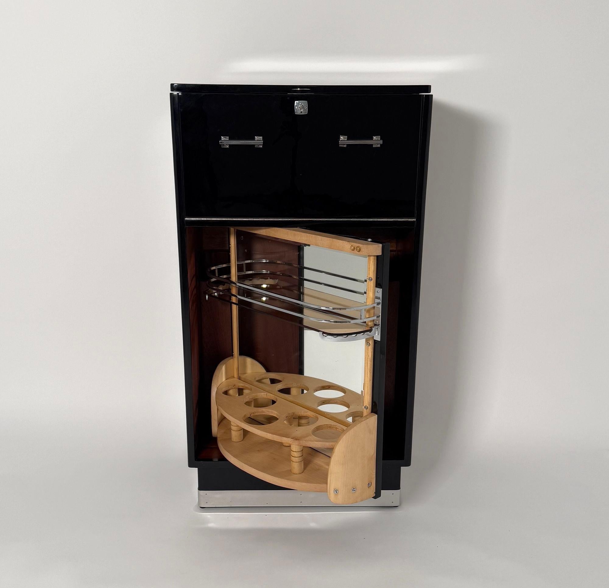 Mobile bar originale Art Deco girevole con accessori cromati, proveniente dalla Francia intorno al 1930.
Noce laccato nero, lucidato a specchio. Interni in legno di acero chiaro, con finitura satinata. Fondo interno in mogano con due scomparti