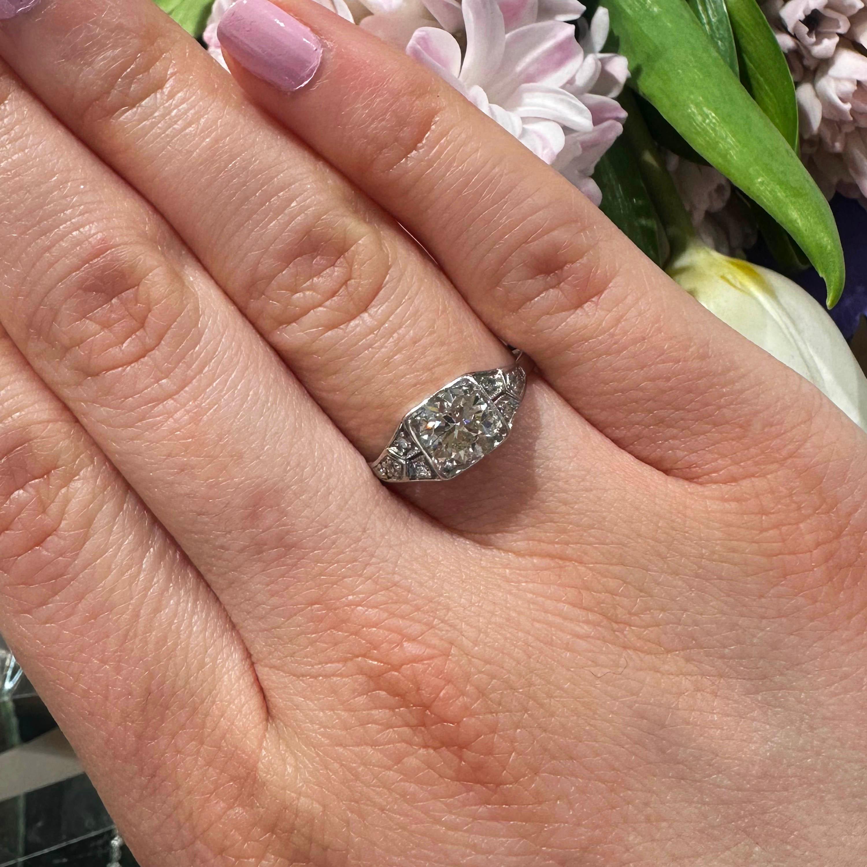An Art Deco diamond ring, set with a round brilliant-cut diamond, weighing approximately 0.80 carats, in the centre, in a grain set square setting, with four eight-cut diamonds, in a geometric design, in each shoulder, with a pierced gallery,