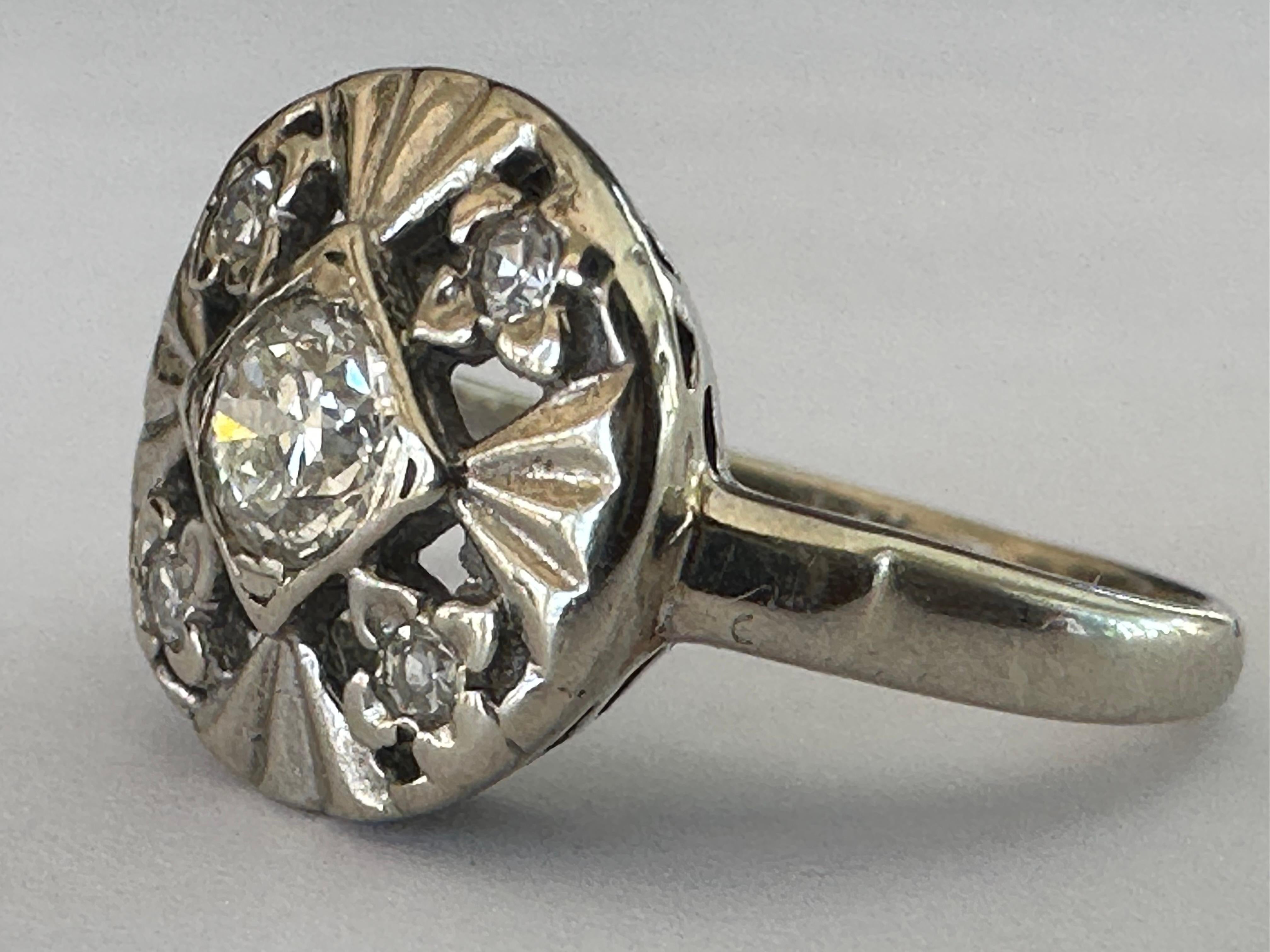 Crafted in the 1930-40s, this late Art Deco round dinner ring sparkles in all directions in a striking petal-like pattern, with four single cut diamonds radiating outward from an Old European cut center stone measuring approximately 0.28 carats, G