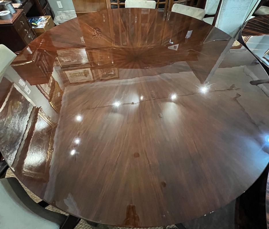 Grand Art Deco French table has a round table top that presents beautiful wood grain. It is elevated by the octagonal shape base, that is also embellished with several brass decorative elements. Table can accommodate around ten chairs.

Condition is