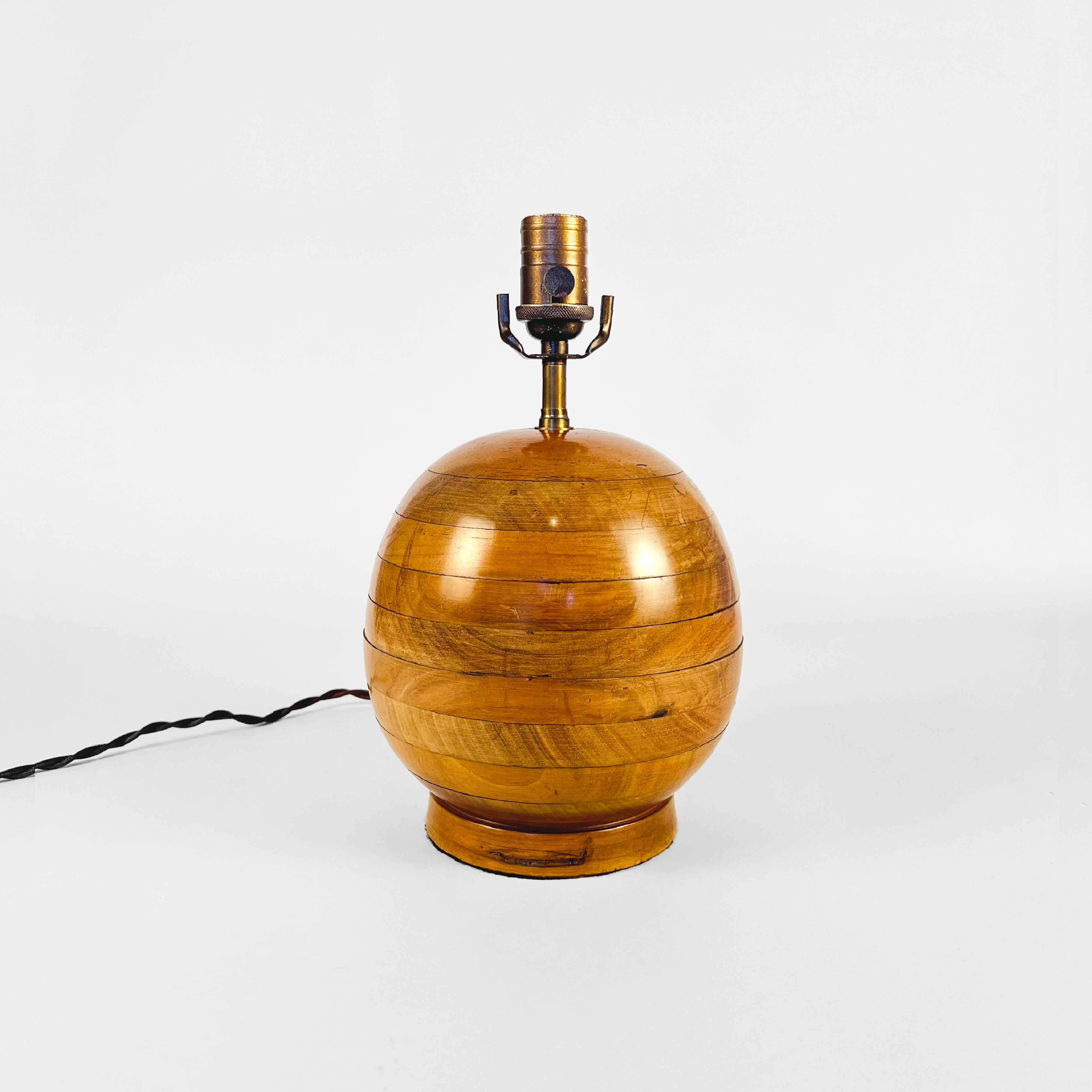 Art Deco round wooden table lamp, circa 1930.
The body is constructed with circular layers made of walnut, and sits on a round wooden base.
This item has been rewired with new hardware and braided cloth cord. This lamp does not include shade or harp.