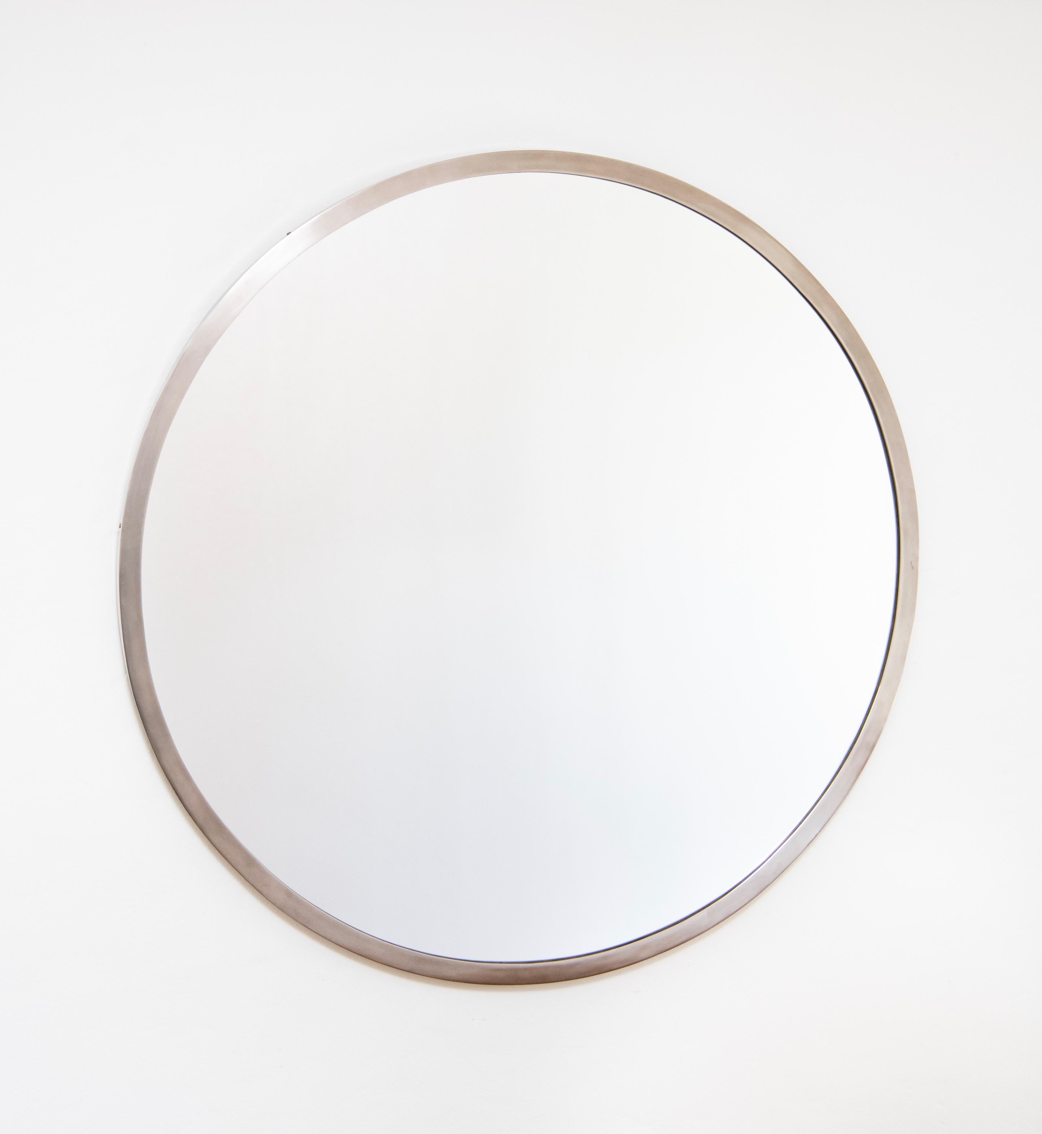 A monumental round mirror in a nickel-plated metal frame. Art deco circa 1930.